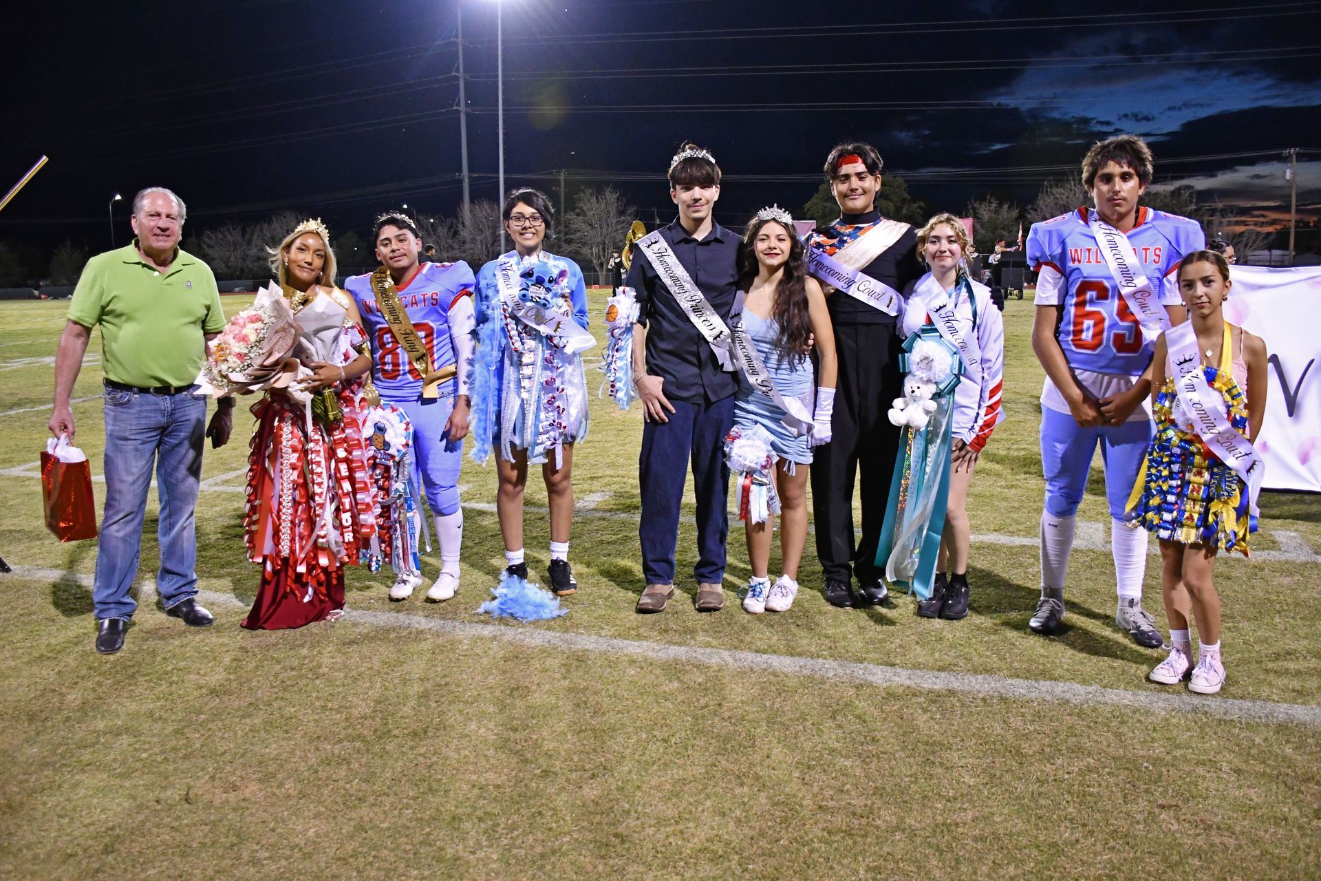 Homecoming court of students wearing mums and smiling at the camera while wearing mums