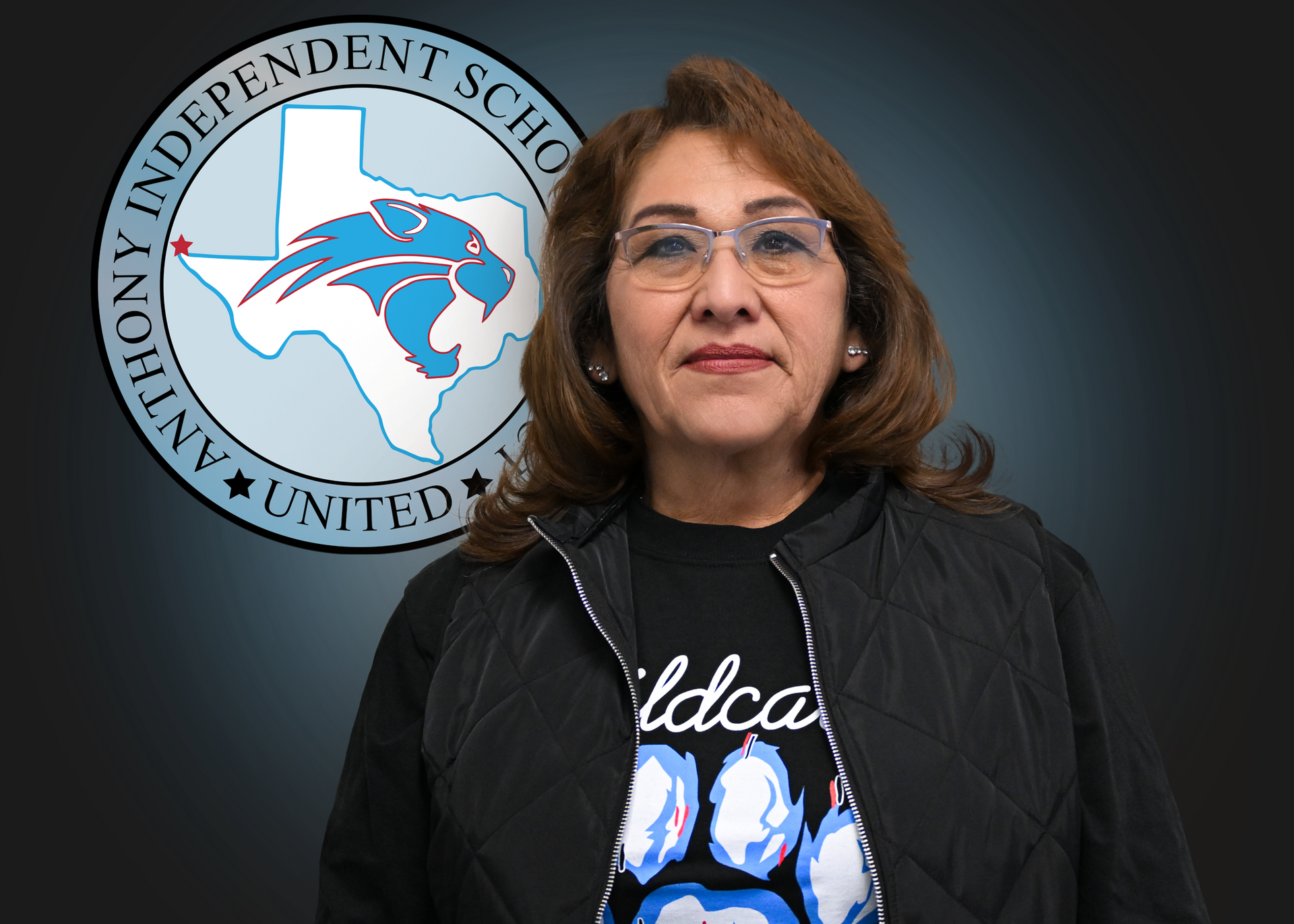 Woman wearing black shirt stands in front of Anthony ISD logo.