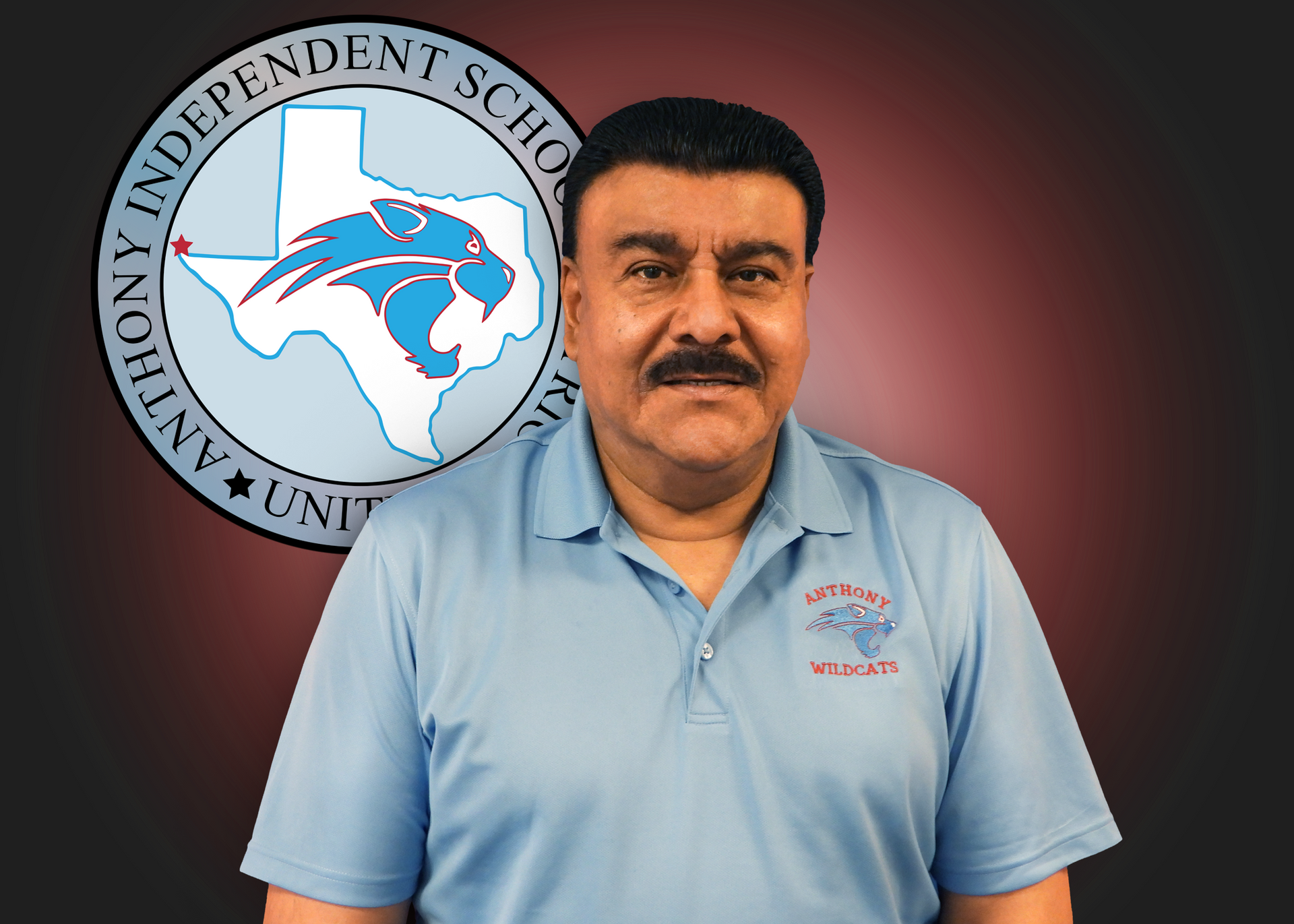 A man in a blue shirt is standing in front of an anthony independent school logo