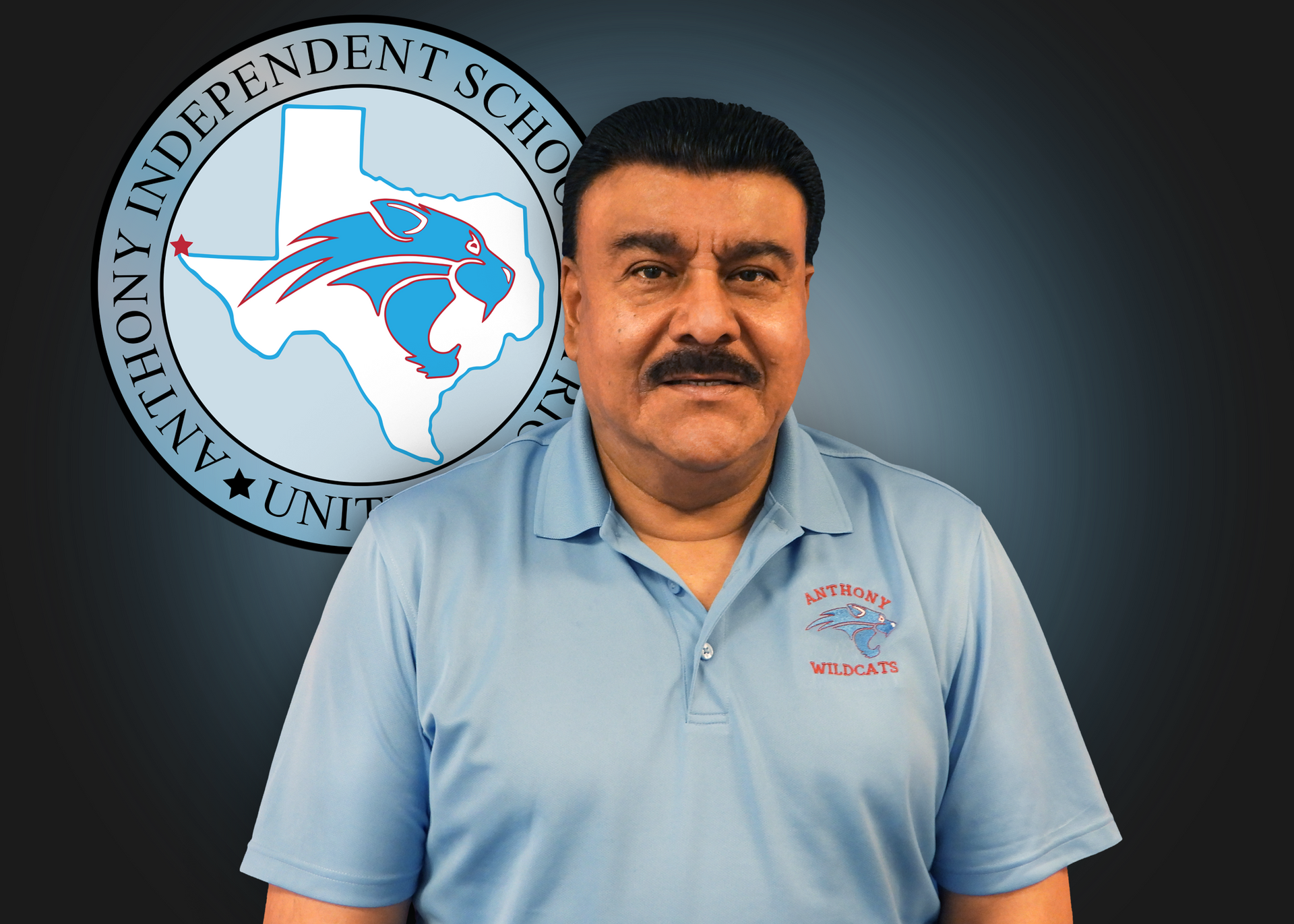 A man in a blue shirt is standing in front of a logo for anthony independent school