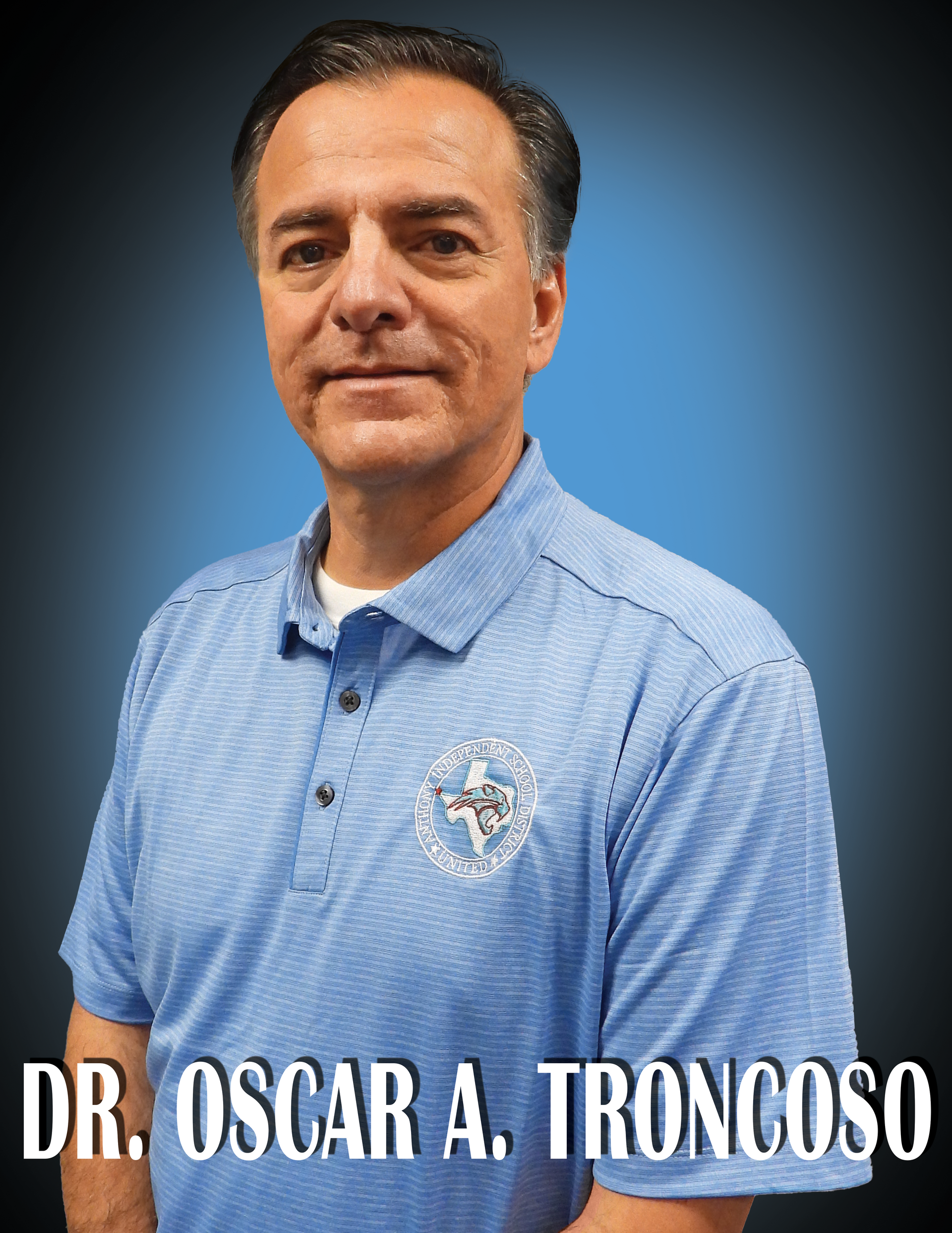 Superintendent Dr. Oscar A. Troncoso wearing a blue shirt standing in front of a blue background.