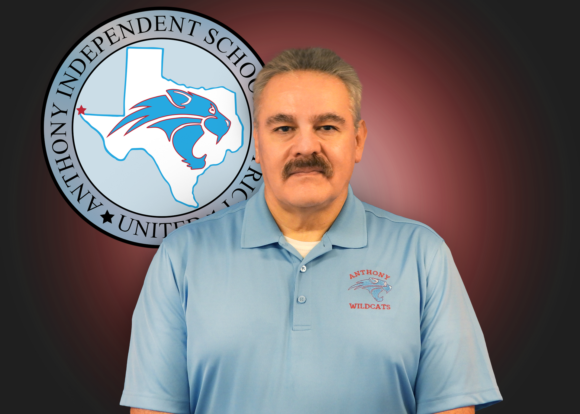 A man is standing in front of a logo for anthony independent school
