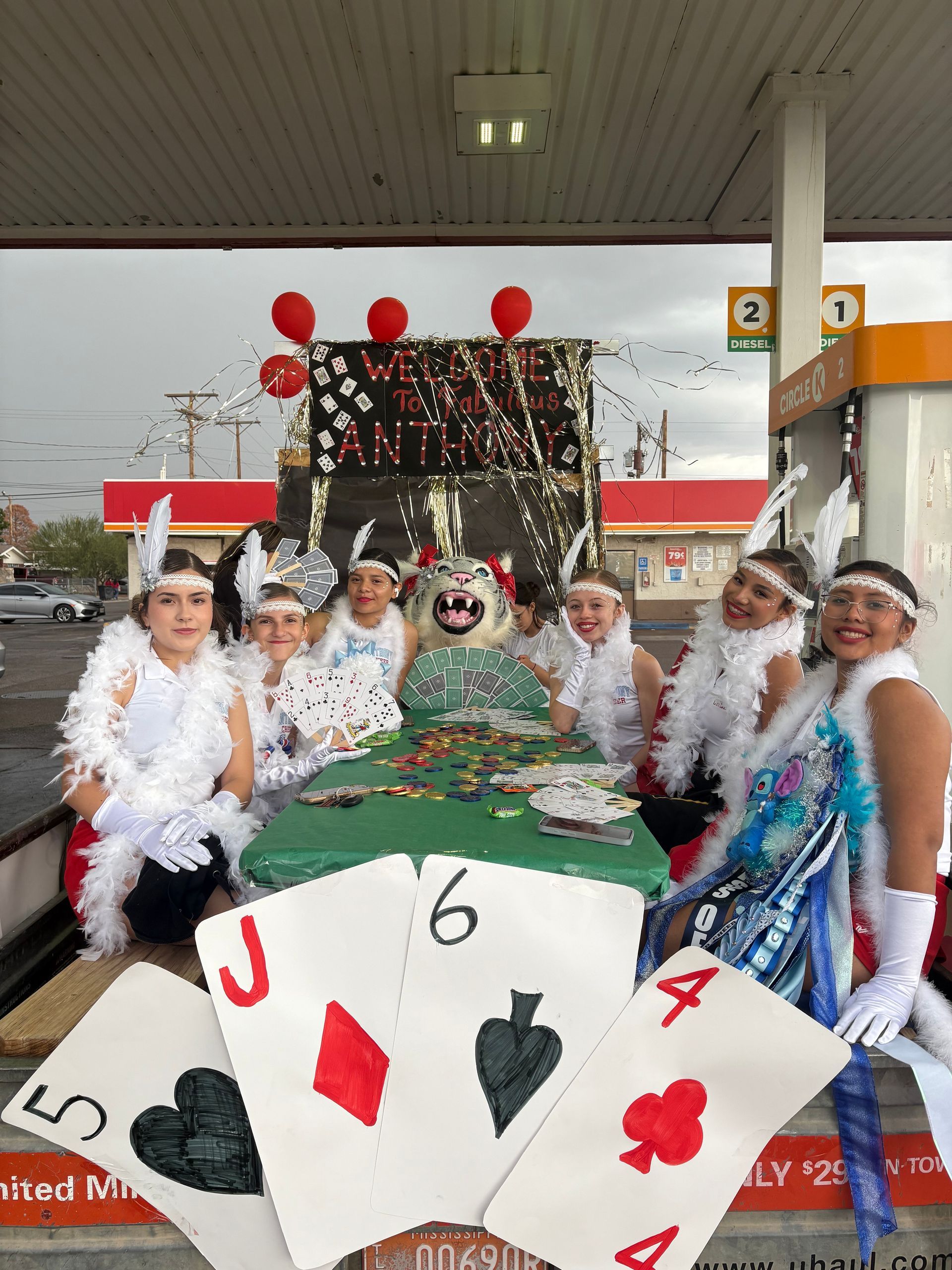 Cheerleaders wear feathers and sit on their homecoming float, designed to resemble a gambling table