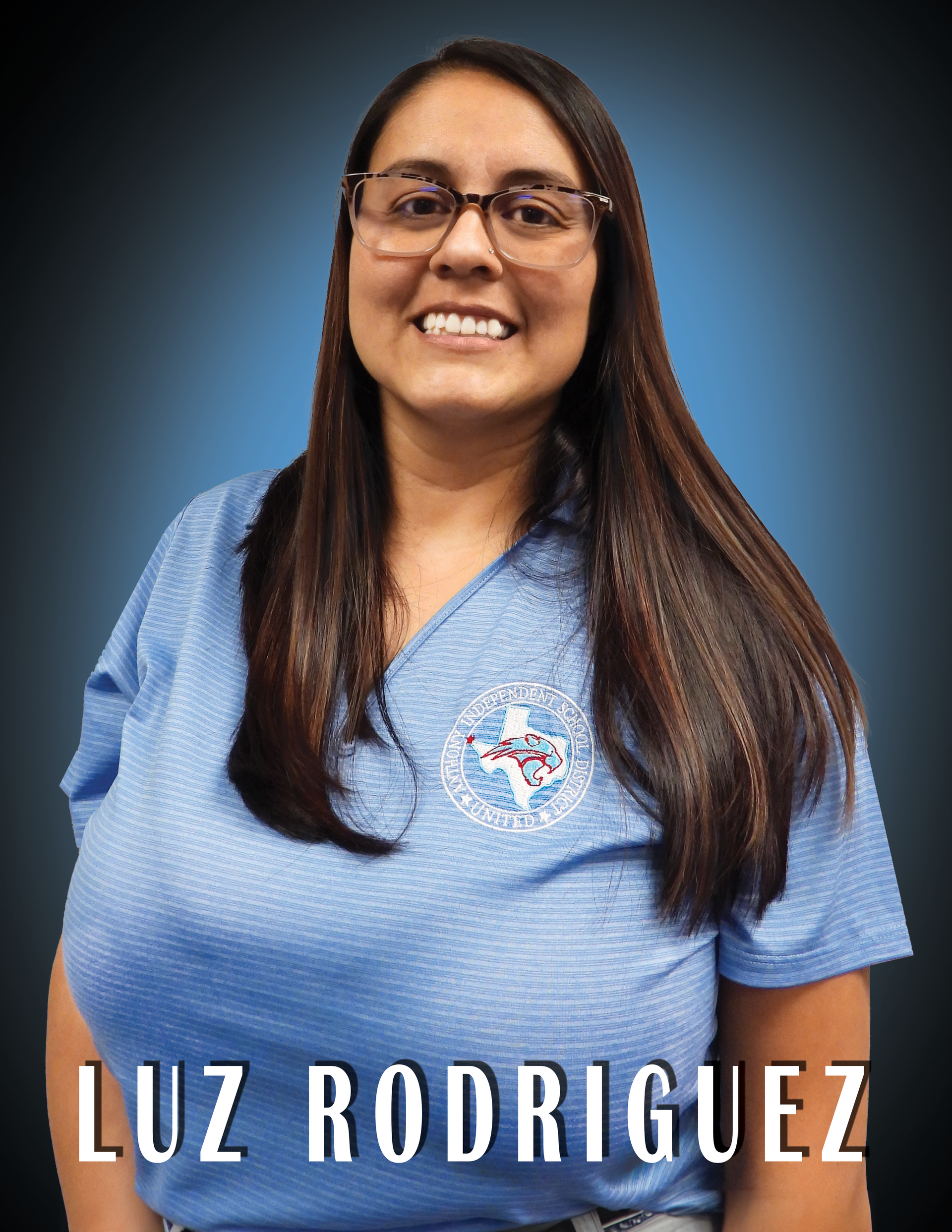 Trustee Luz Rodriguez wearing a blue shirt standing in front of a blue background.
