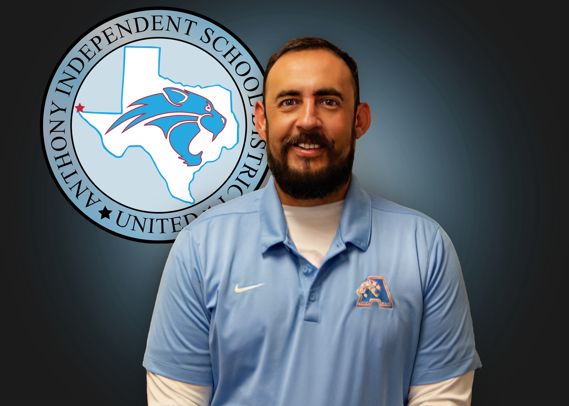 A man in a blue shirt is standing in front of a logo for anthony independent school district.