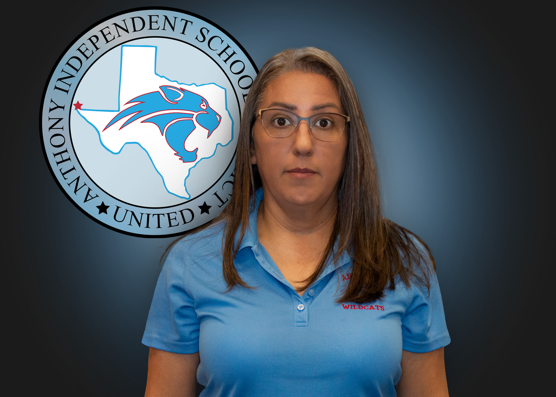 A woman in a blue shirt is standing in front of a logo for anthony independent school