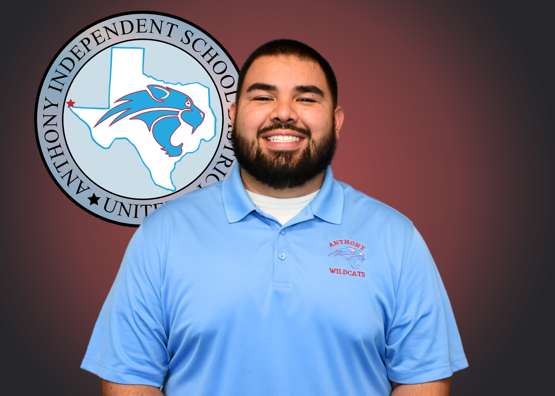 Man wearing blue polo shirt stands in front of independent school district logo