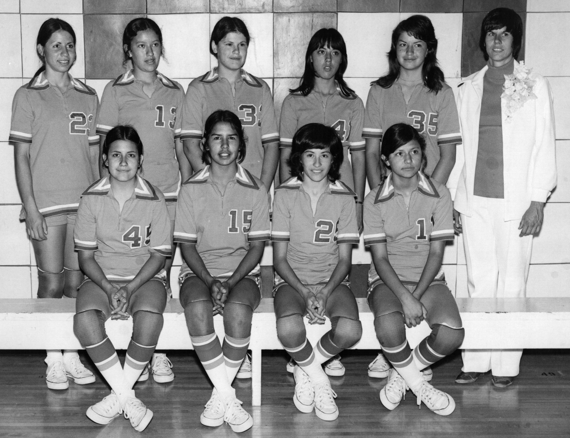 Black and white photo from the mid 1970's showing Anthony High School volleyball team and their head coach.