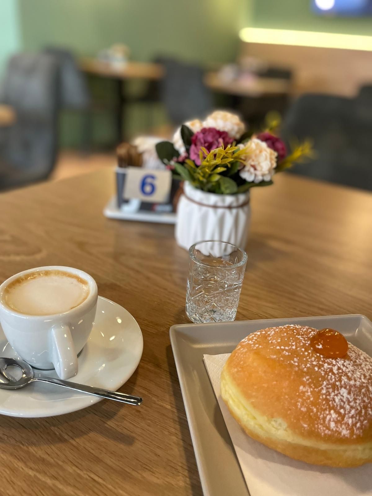 Un tavolo con sopra una tazza di caffè e una ciambella.