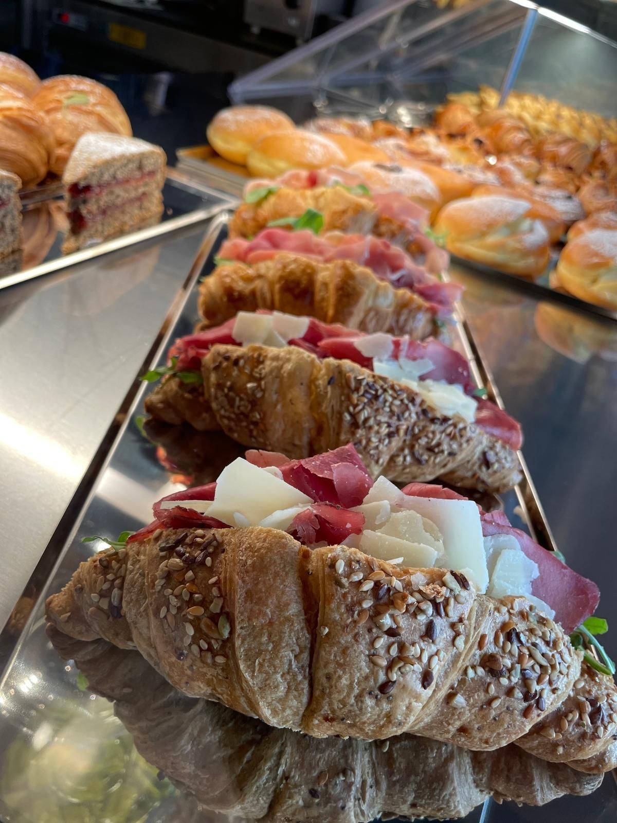 Una fila di croissant con condimenti diversi su un vassoio.