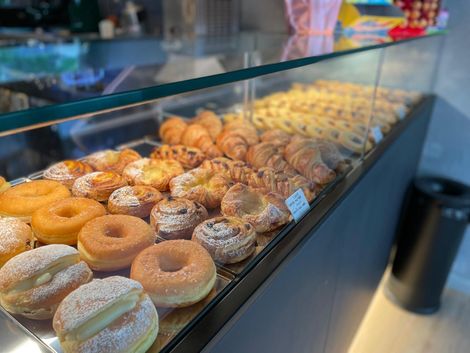 Una vetrina piena di ciambelle e pasticcini in una panetteria.