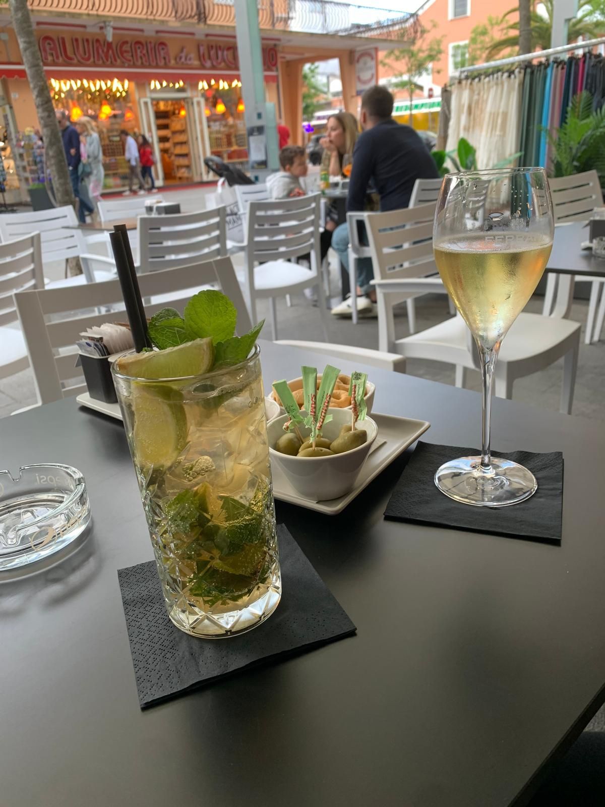 Un tavolo con sopra una bevanda e un bicchiere di vino