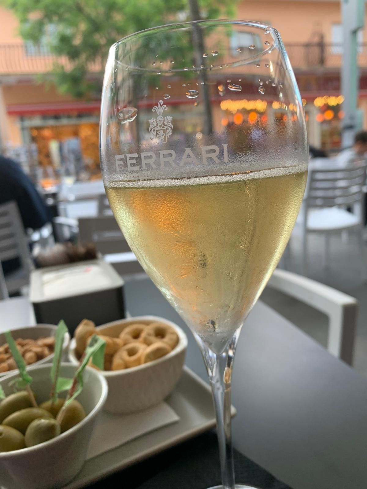 Un bicchiere di vino ferrari è seduto su un tavolo.