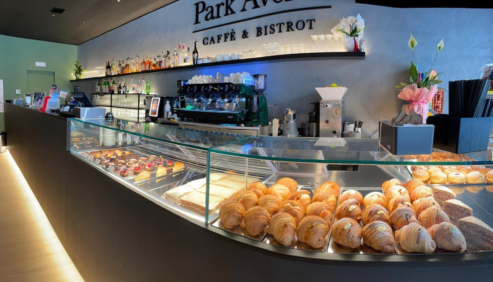 Una vetrina piena di croissant e pasticcini in un ristorante.