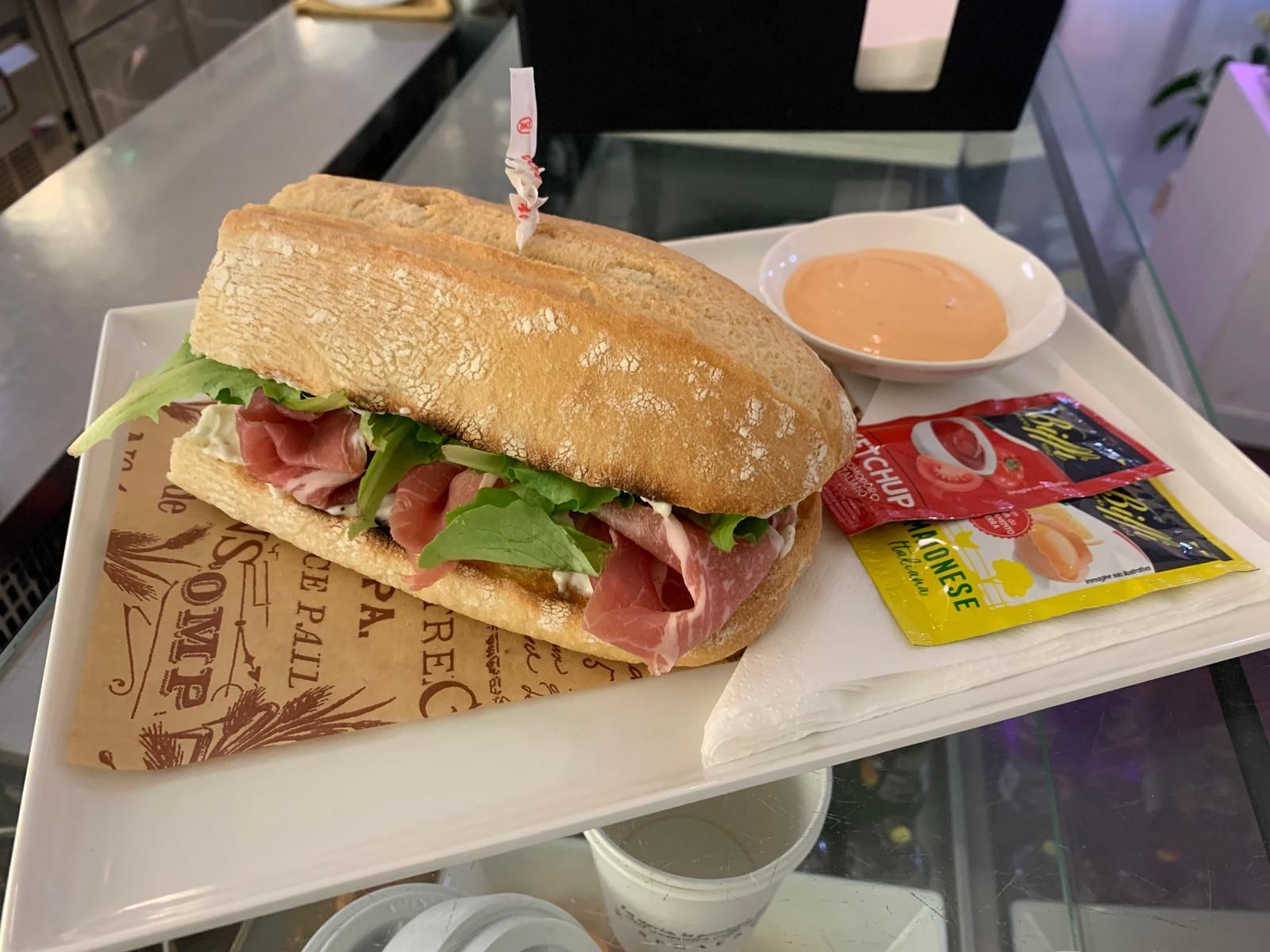 Un panino è seduto su un piatto bianco su un tavolo.