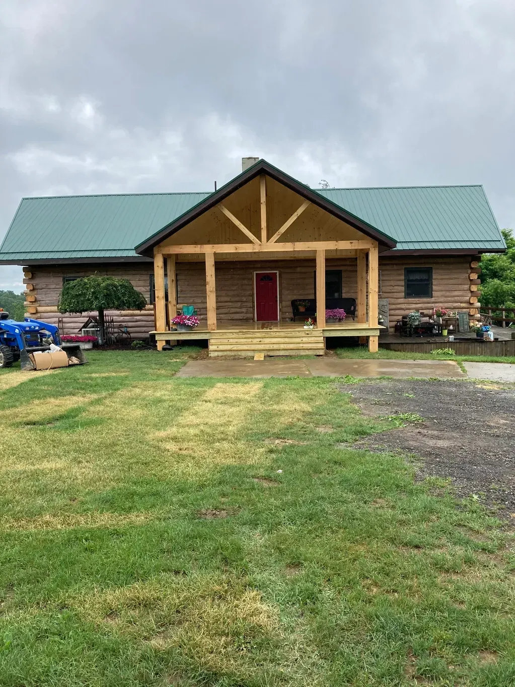 A Log Cabin With A Porch And A Blue Truck Parked In Front Of It - Salineville, OH - Eastern Ohio Builders LLC