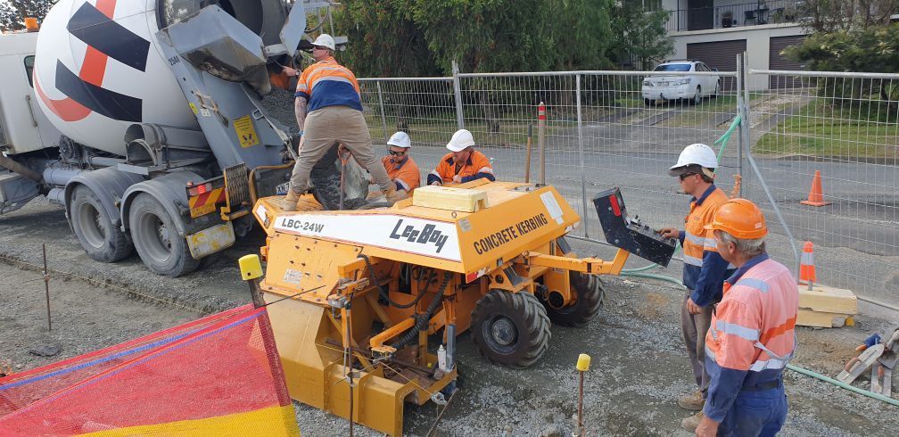 Workers  Beside Concrete Kerbing Machinery — Projects in Coopernook, NSW