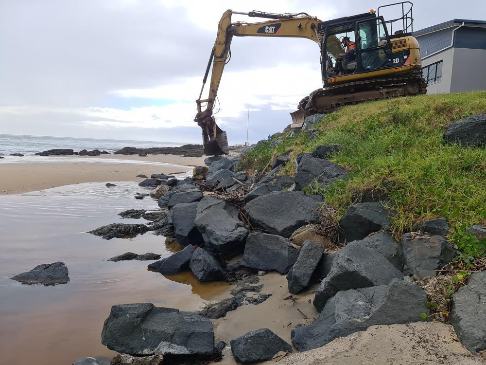 Excavator Lifting Rocks On Beach — Projects in Coopernook, NSW