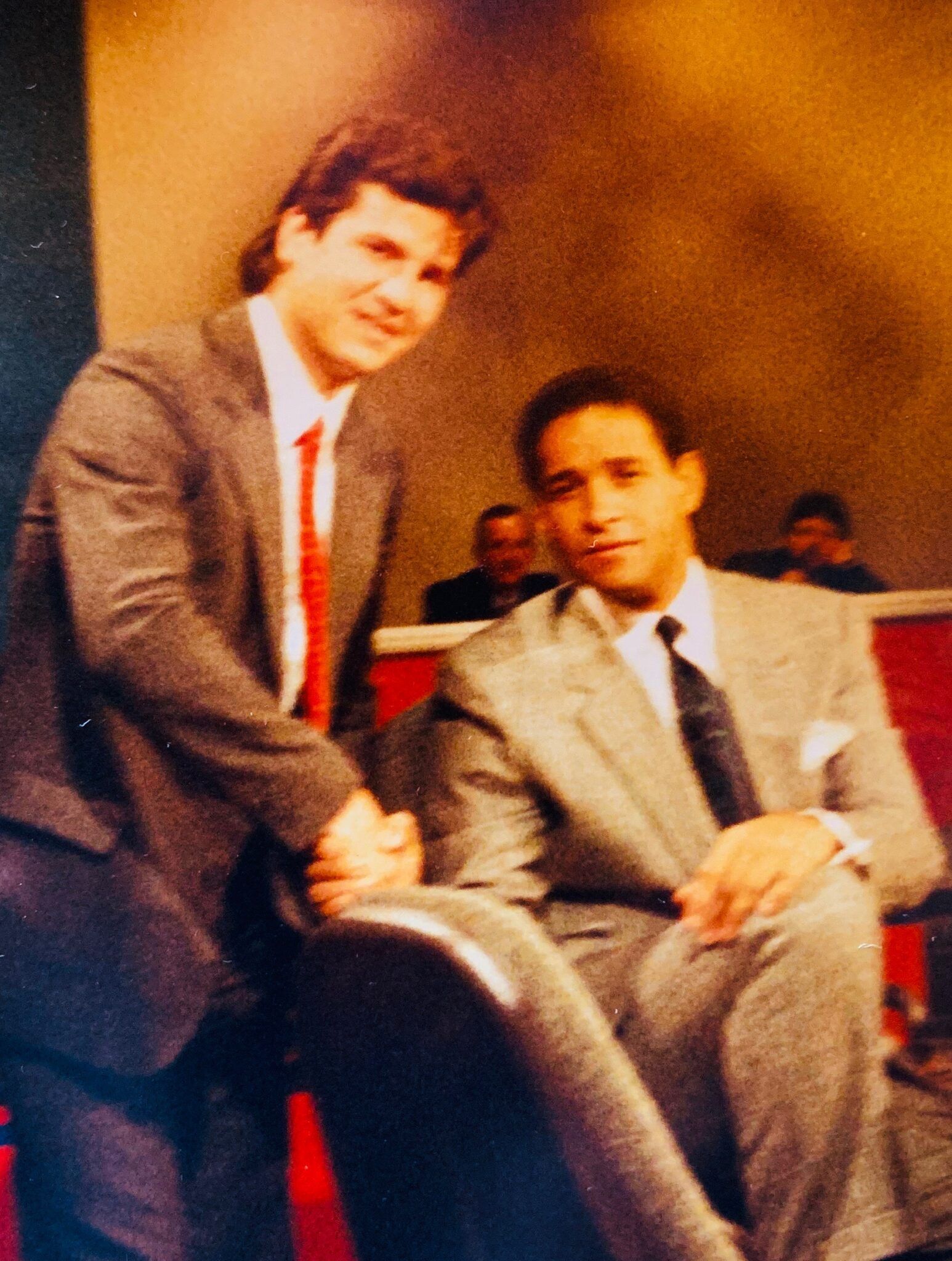 A man in a suit and tie is shaking hands with another man