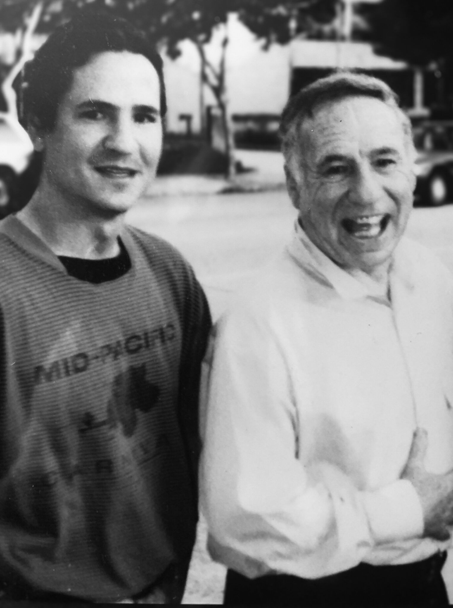 Two men standing next to each other one wearing a shirt that says mid-tech