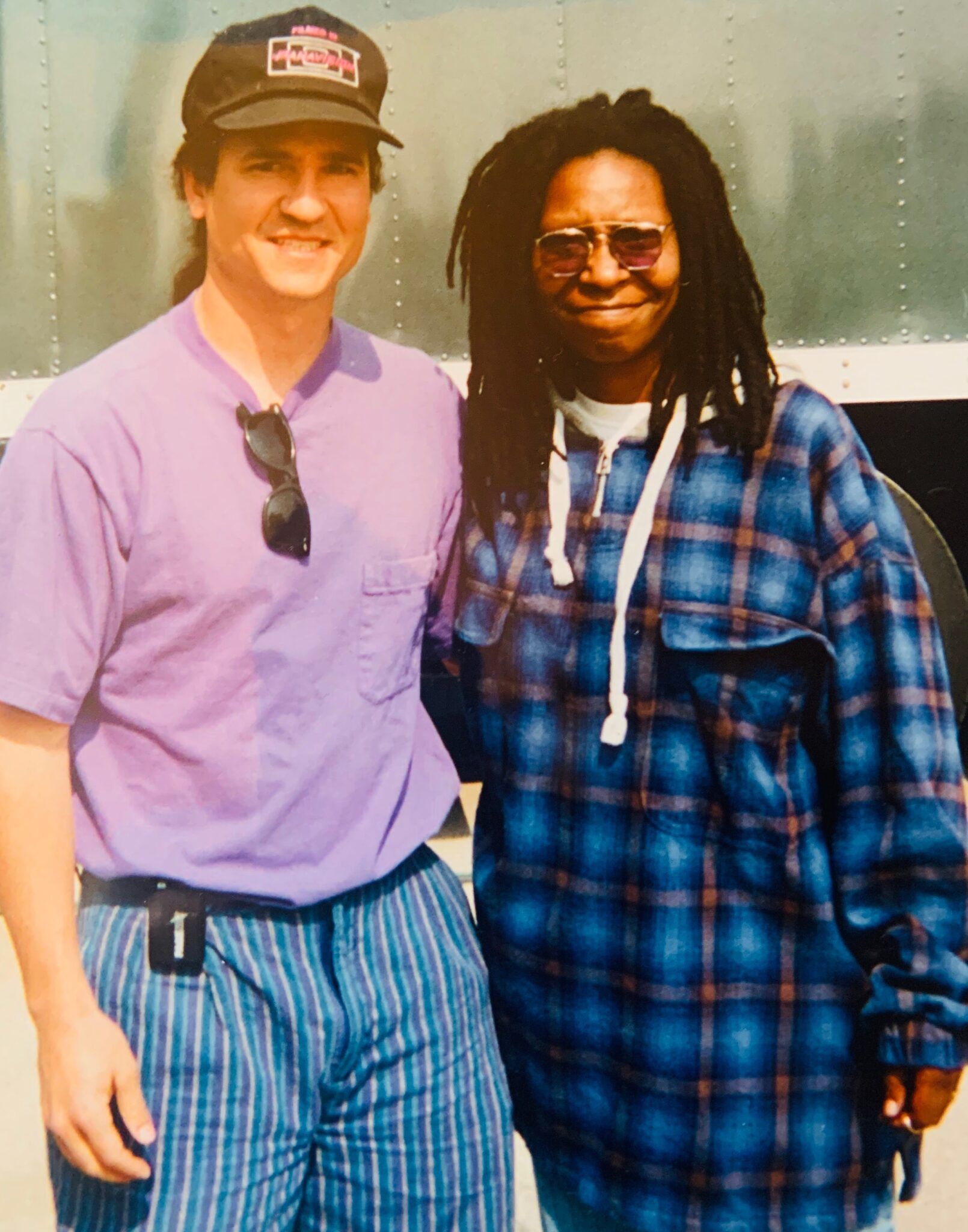 A man in a purple shirt stands next to a woman in a plaid shirt