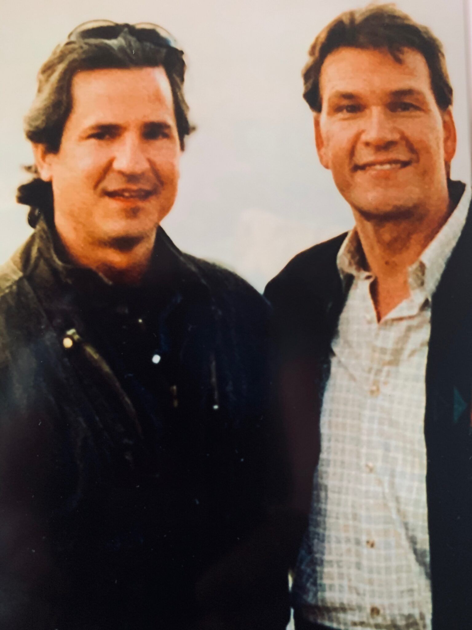 Two men standing next to each other and smiling for the camera