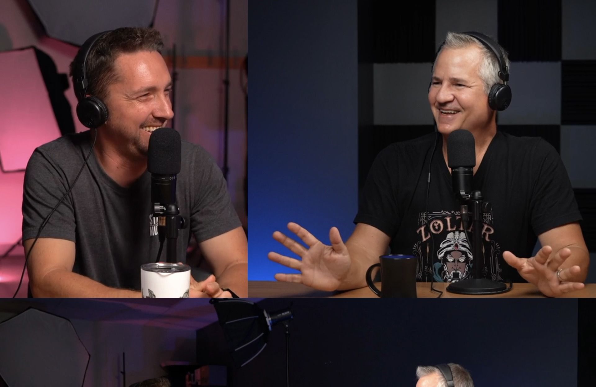 Two men are sitting at a table talking into microphones.