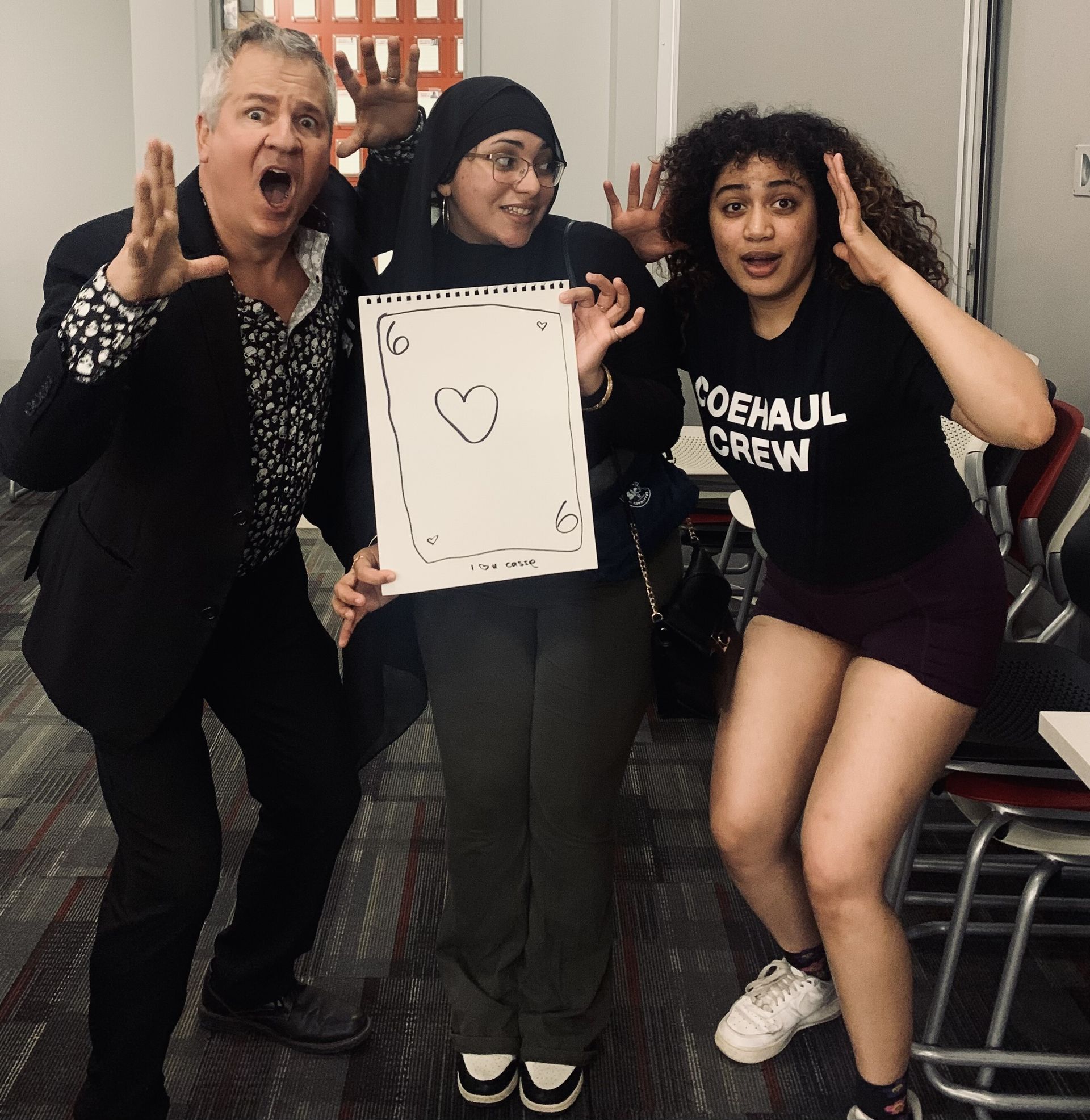 A woman wearing a black shirt that says coexaul crew