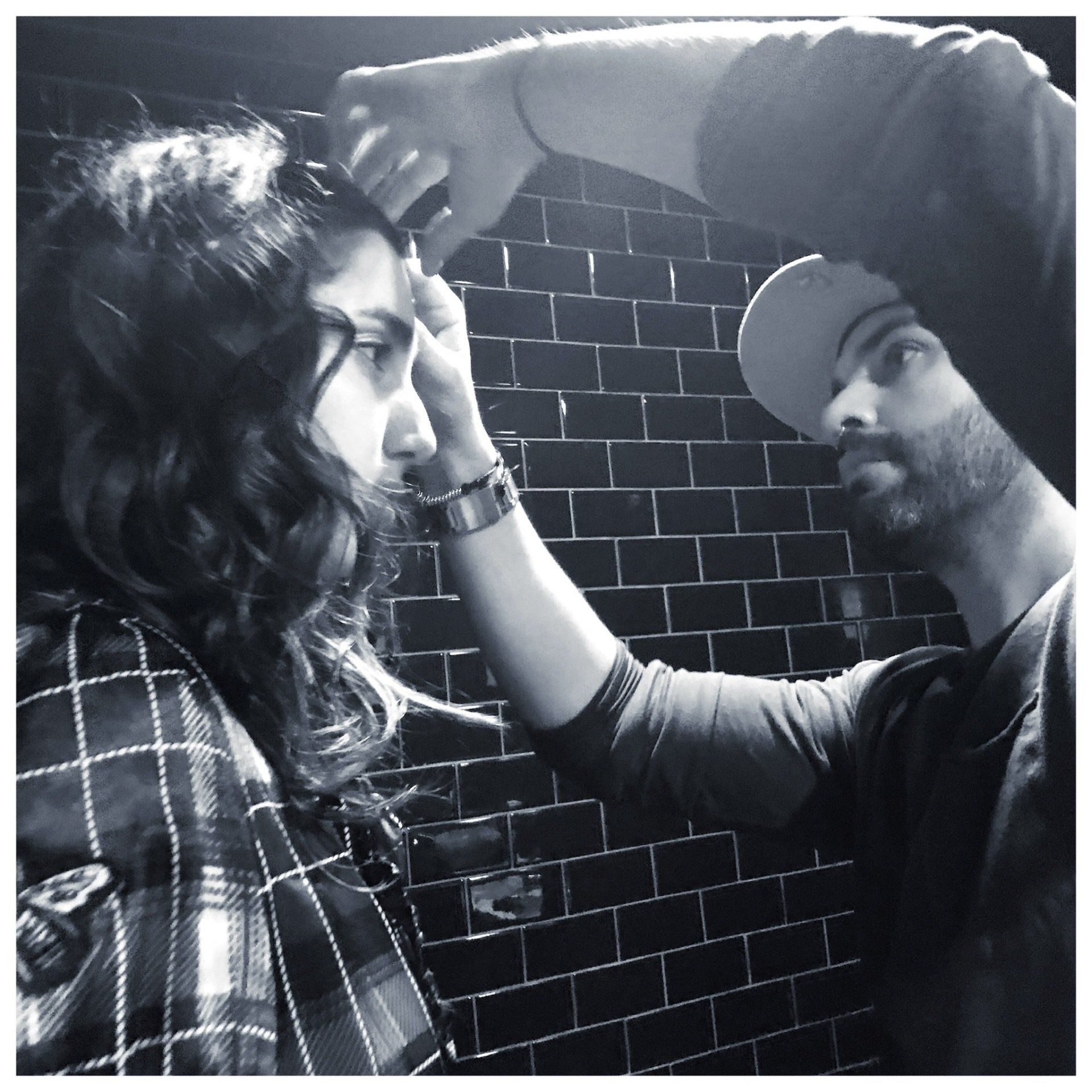 Hairstylist on set, working with woman with curly hair