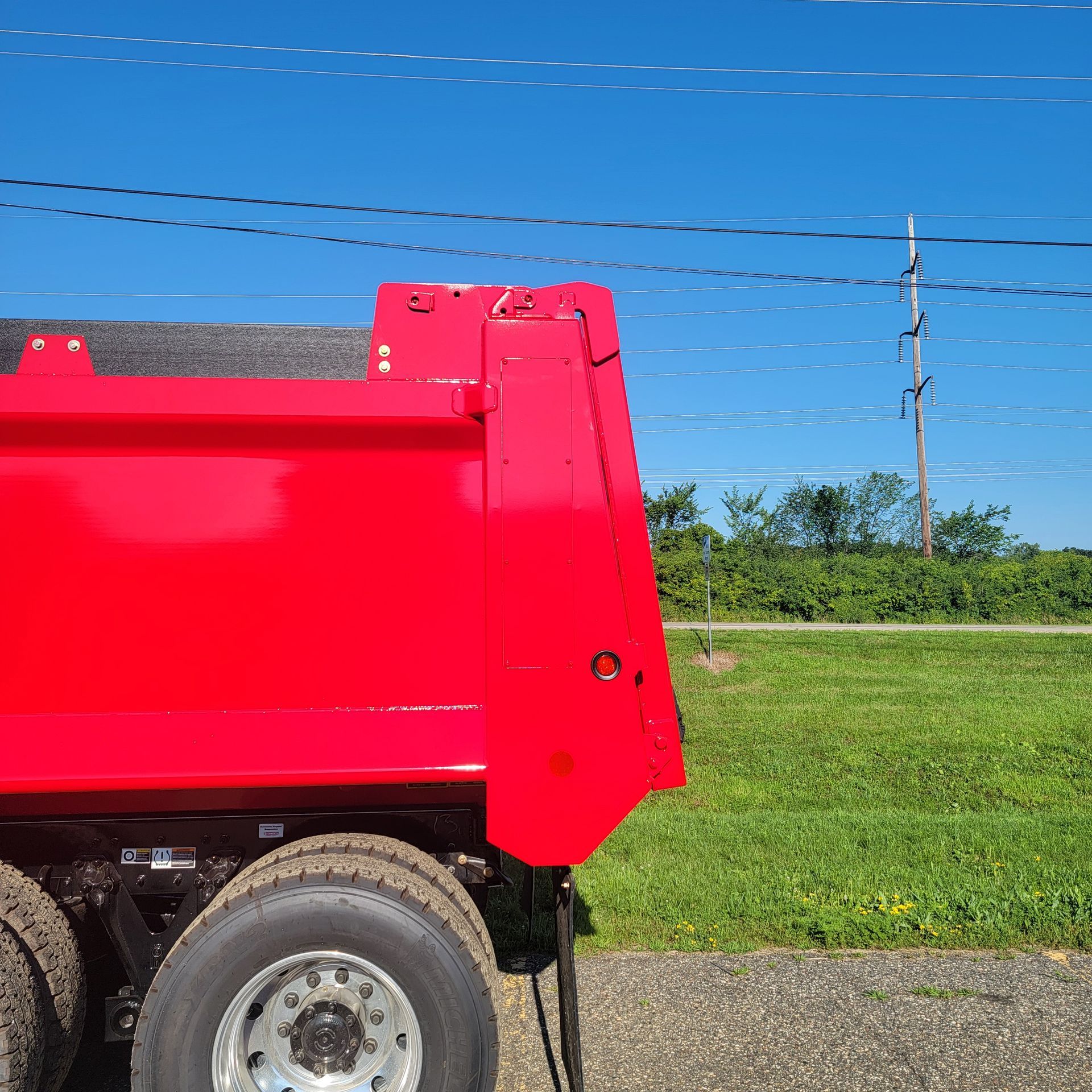 A red dump truck is parked on the side of the road