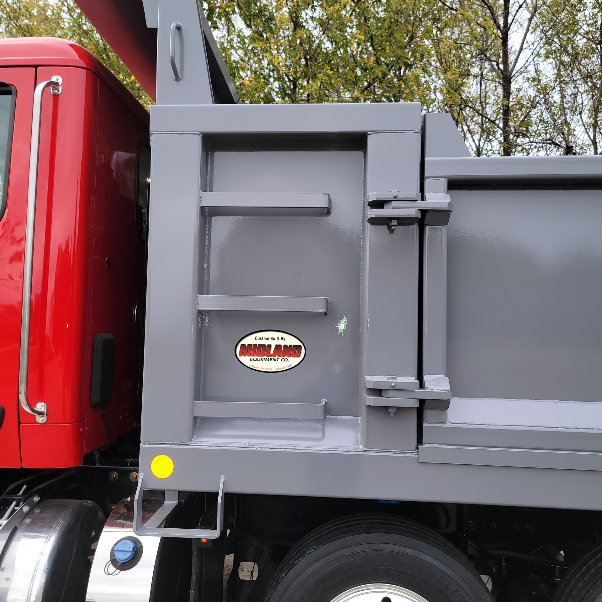 A red dump truck has a sticker on the side that says heavy duty