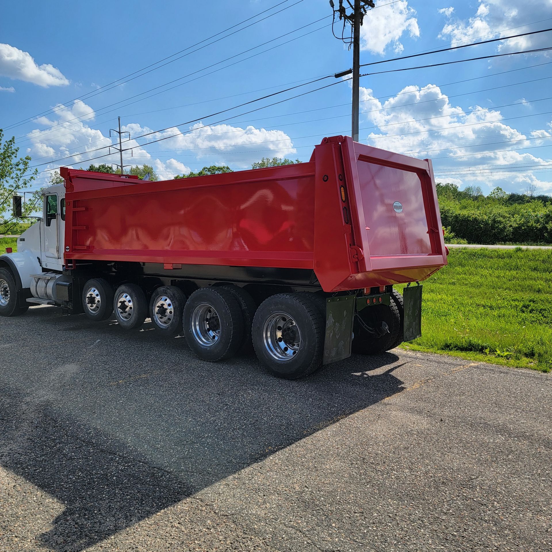A red dump truck is parked on the side of the road