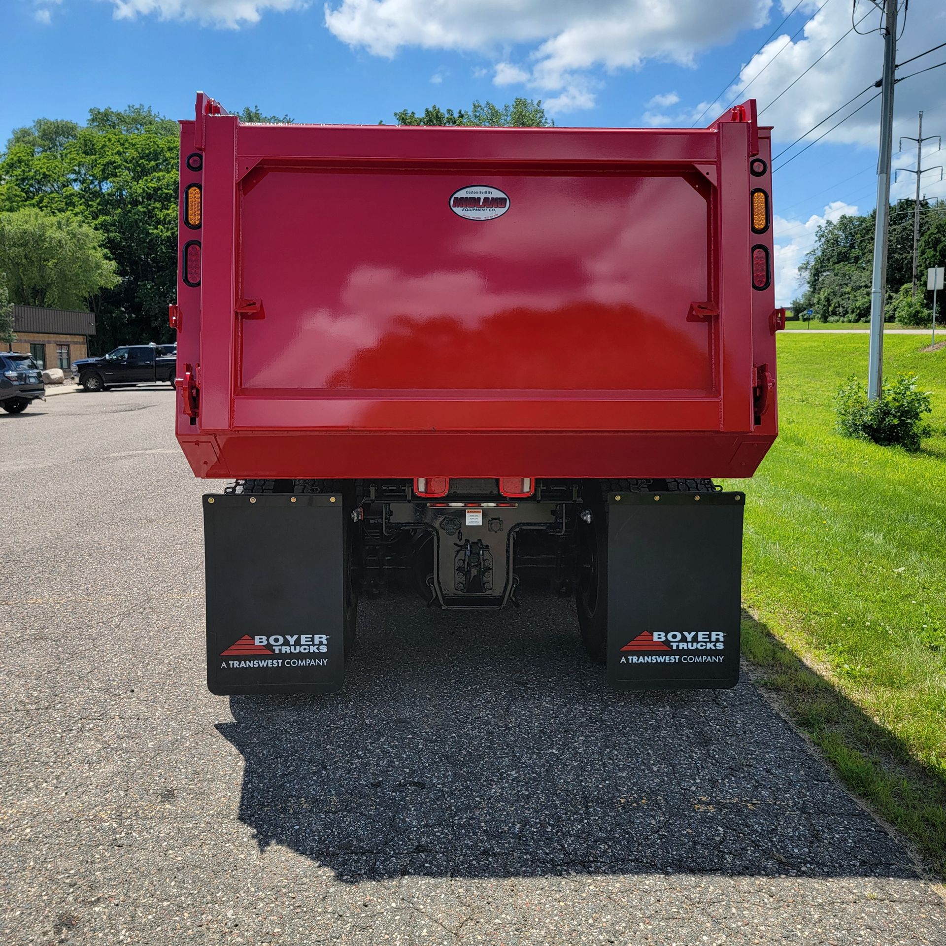 A red dump truck is parked on the side of the road