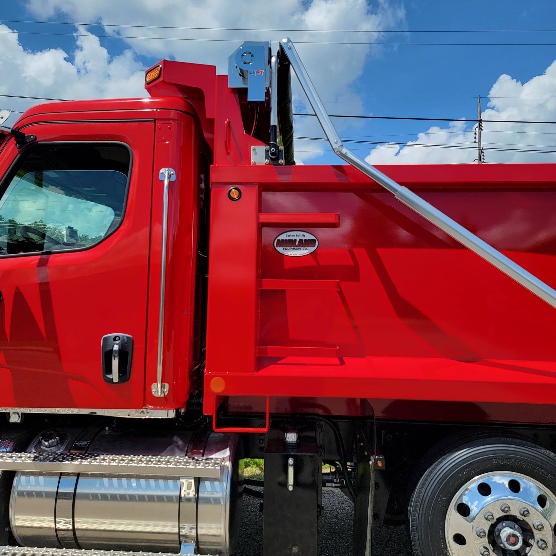A red dump truck is parked on the side of the road