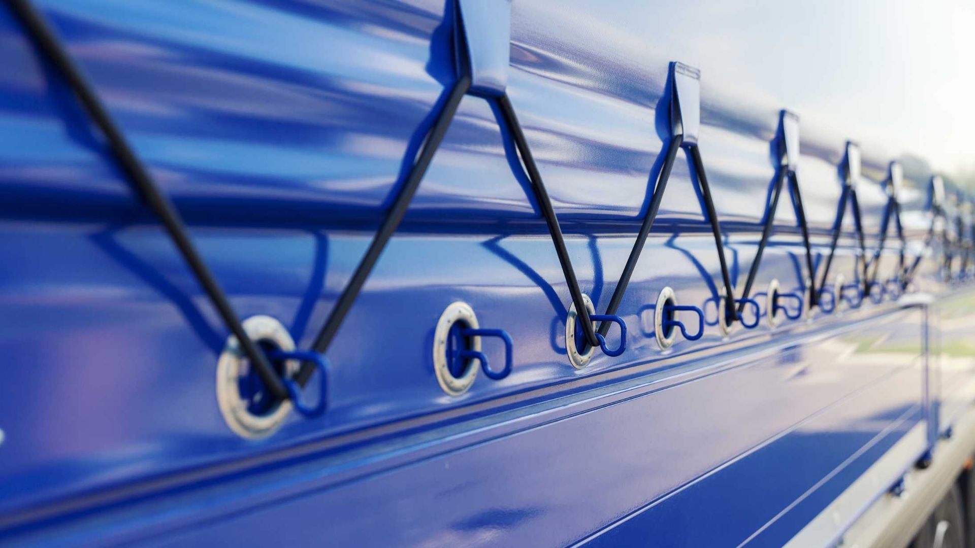 A close up of a blue truck with a tarp on it.