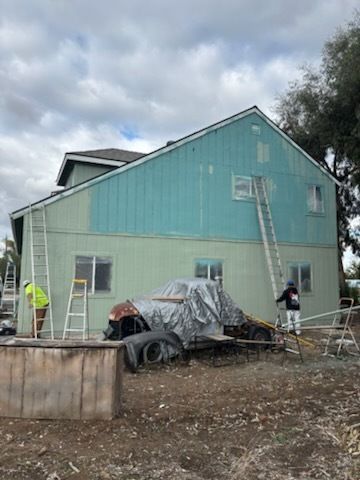 Red, weathered building with a black railing on top, 