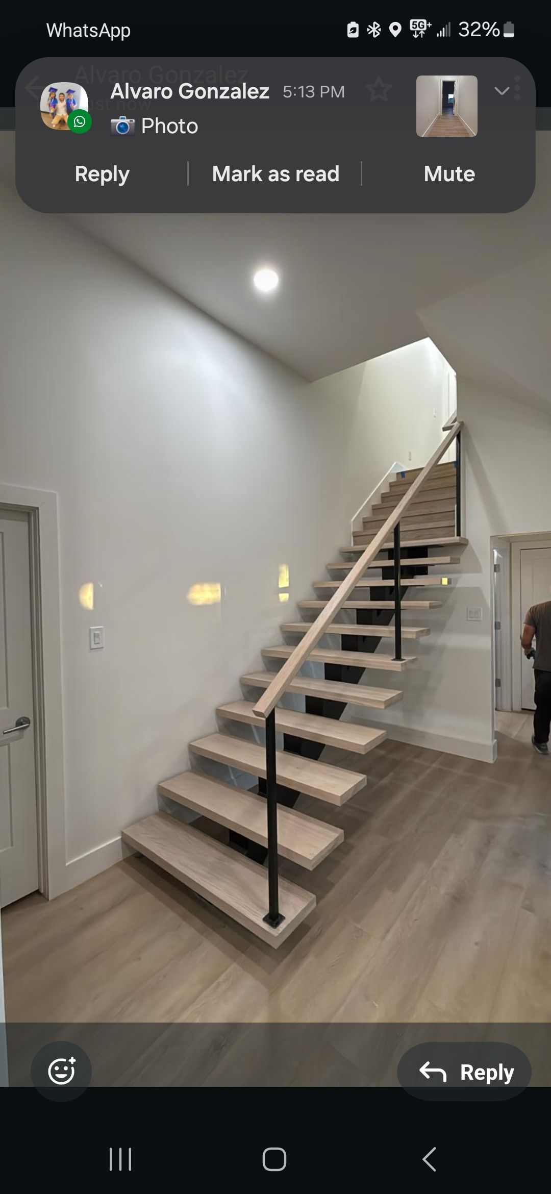 A picture of a staircase in a house on a cell phone.