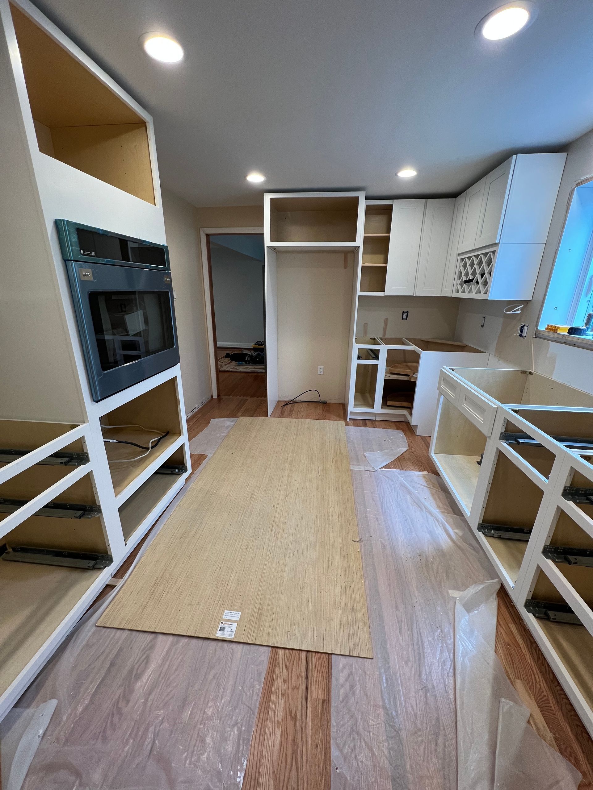 A kitchen under construction with a rug on the floor.
