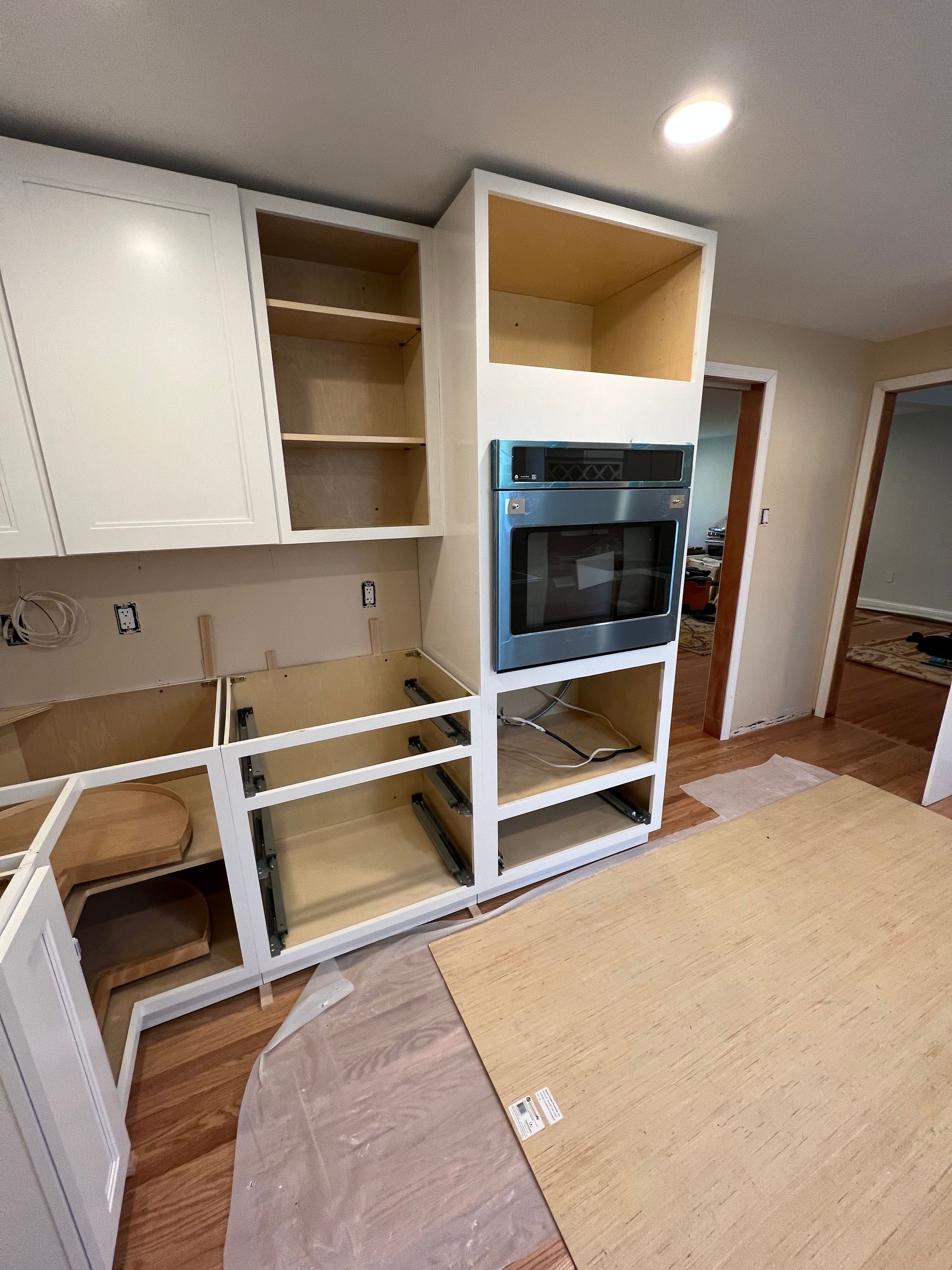 A kitchen with white cabinets and a stainless steel oven.