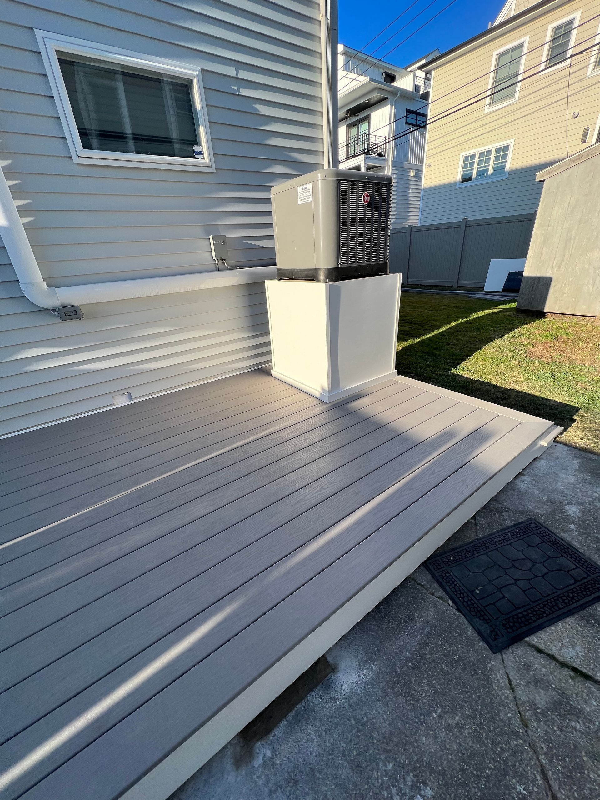 A deck with a heater on it next to a house.