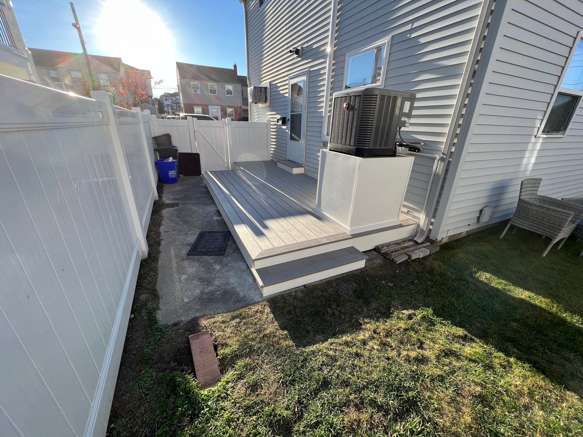 The backyard of a house with a deck and a fence.