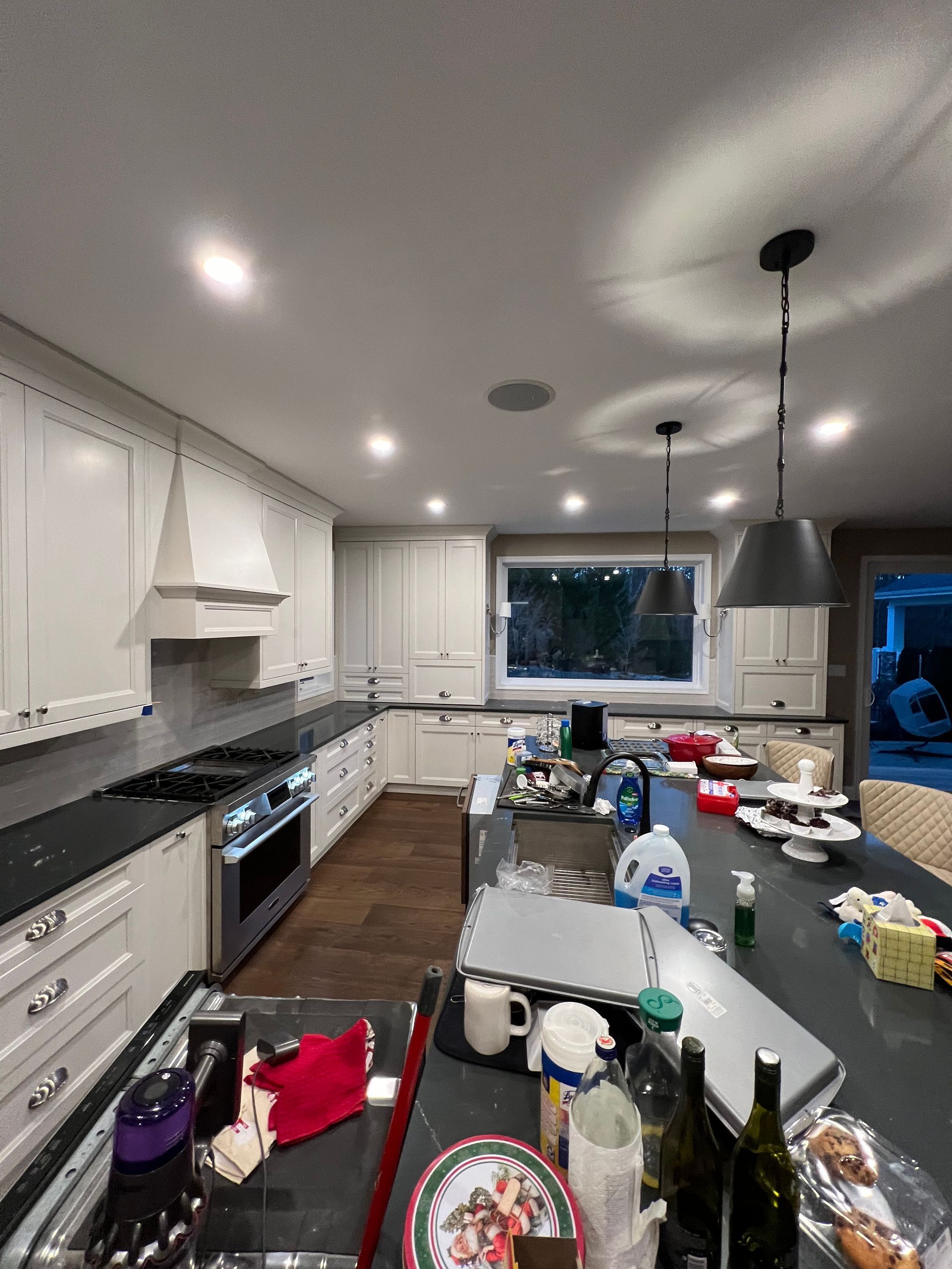 A kitchen with white cabinets and black counter tops