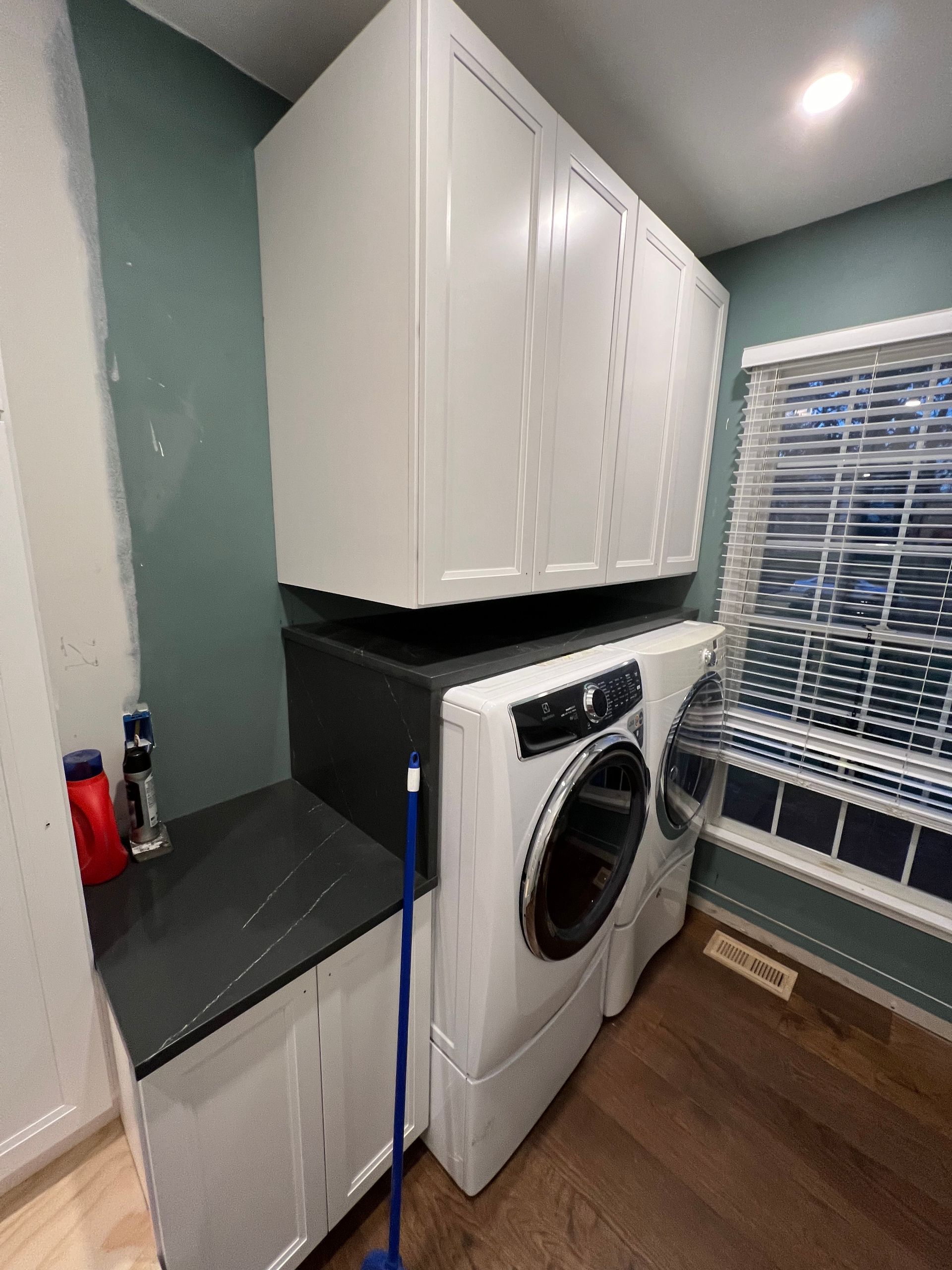 A laundry room with a washer and dryer and a window.