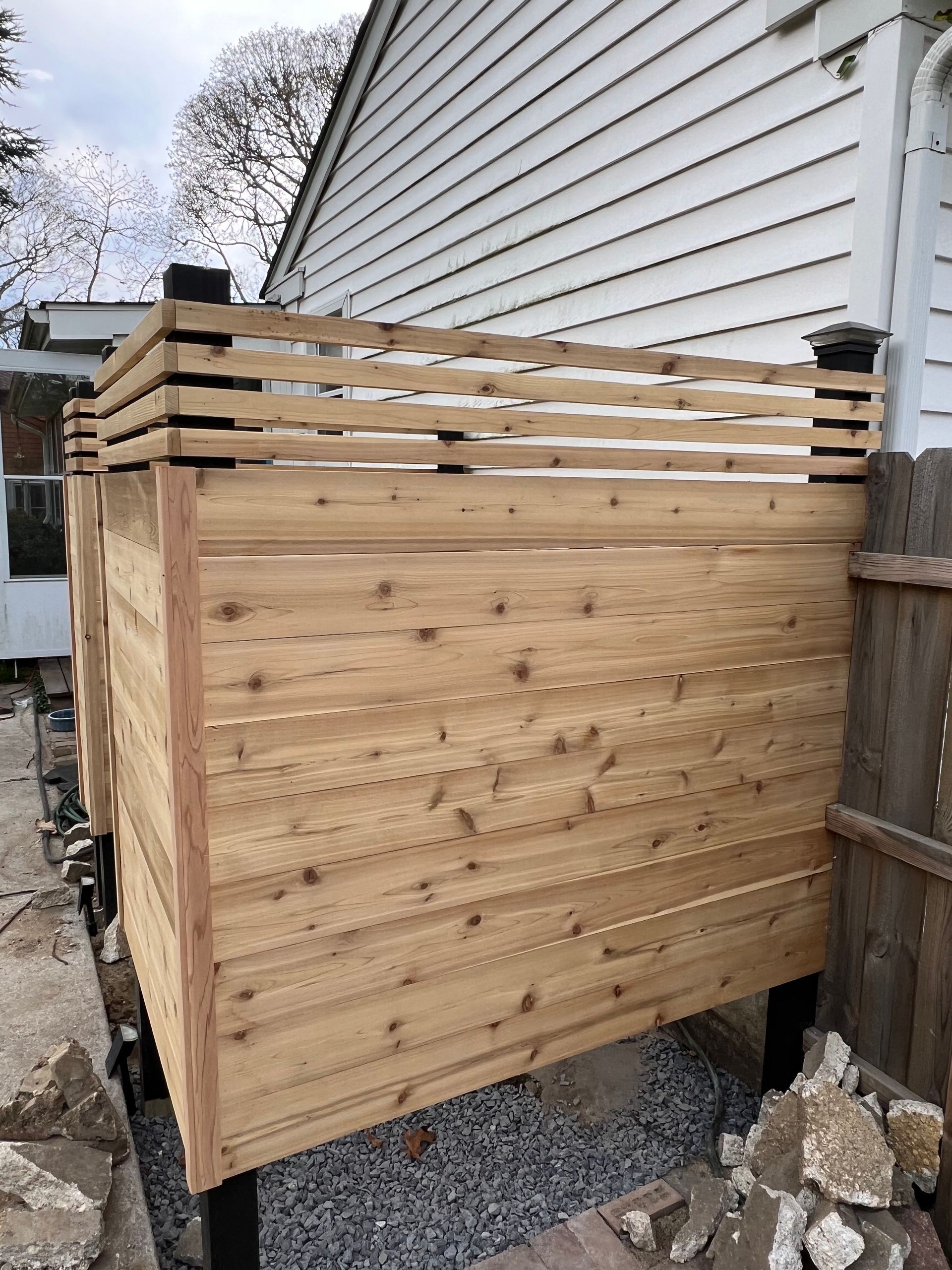 A wooden fence is sitting in front of a house.