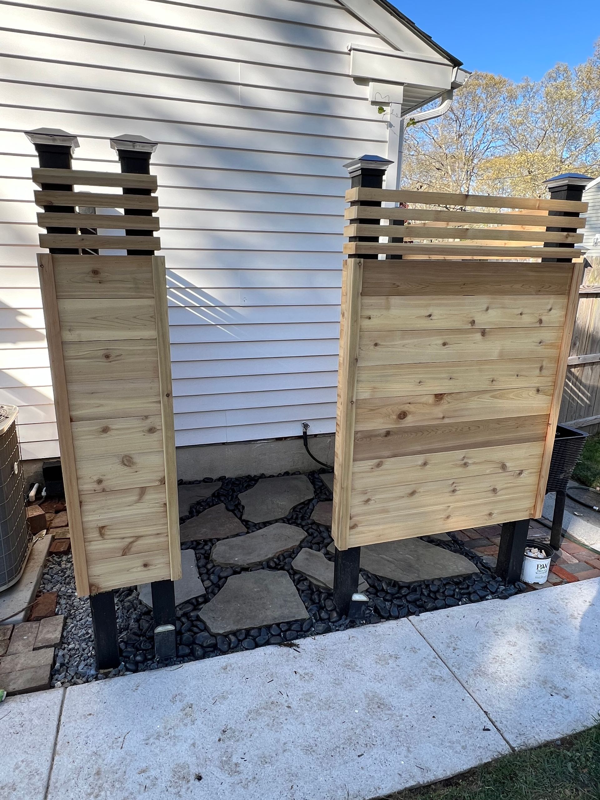 A wooden fence is sitting on the sidewalk in front of a house.