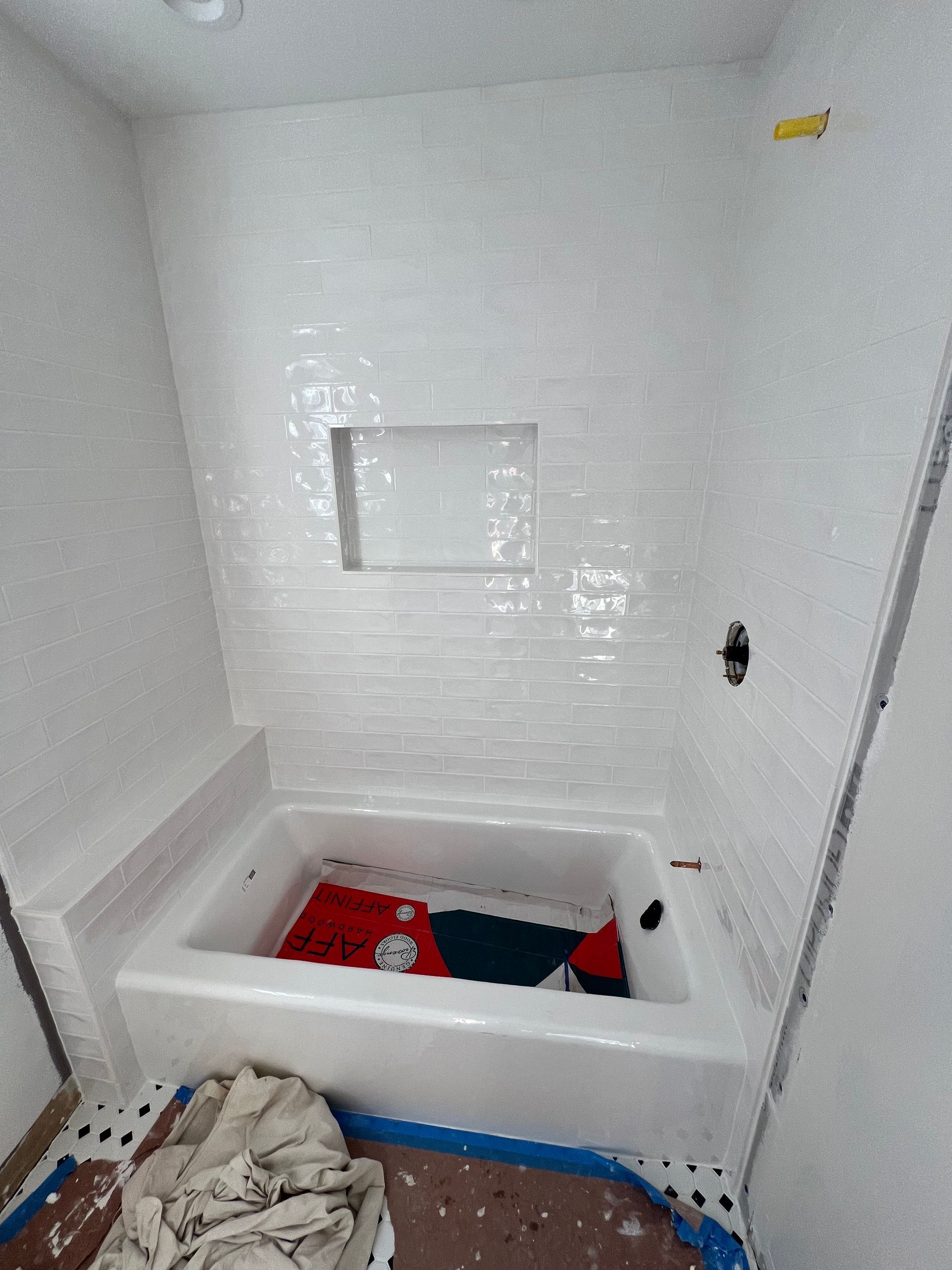 A bathtub is sitting in a bathroom under construction.