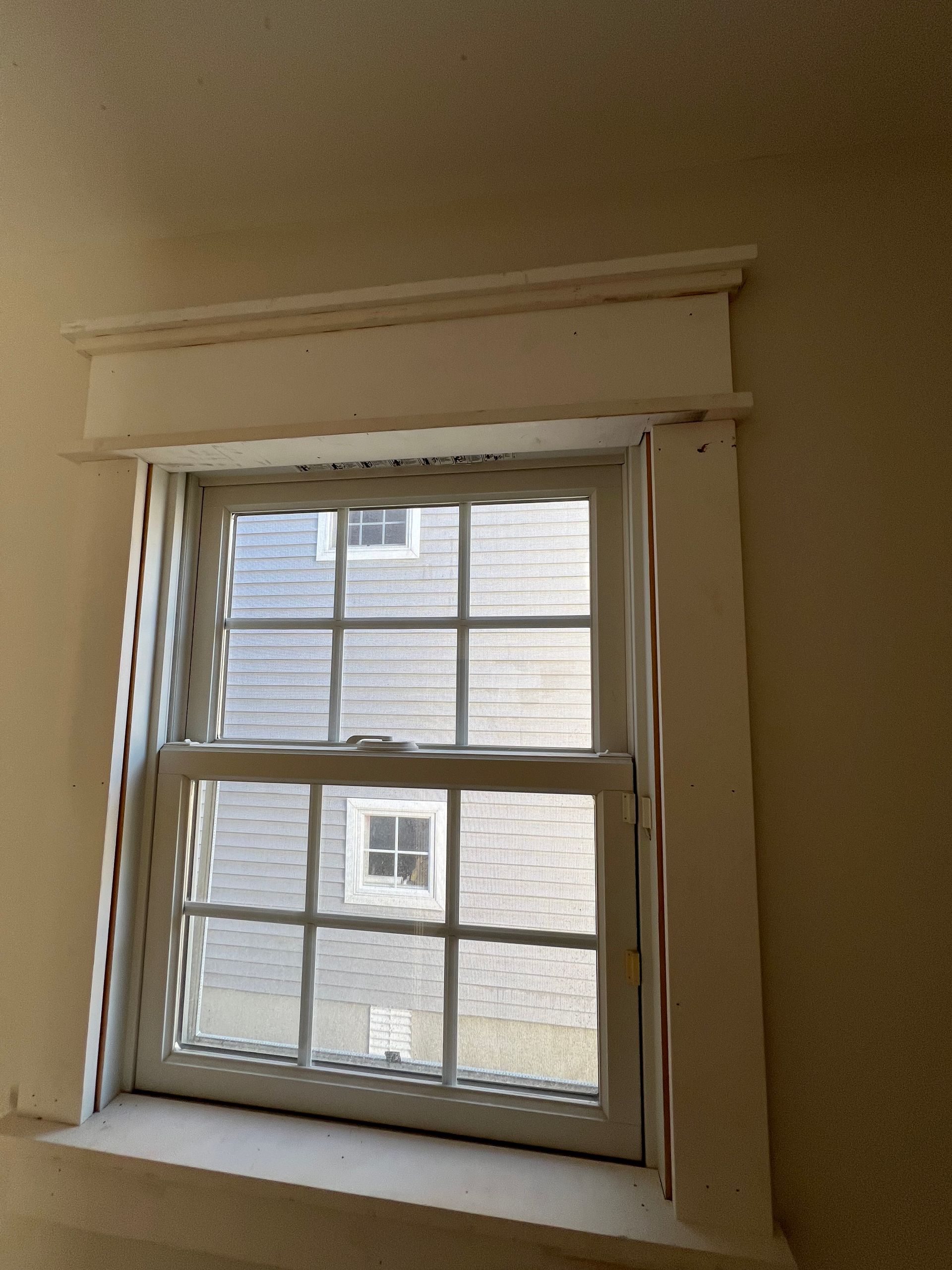 A window in a room with a house in the background