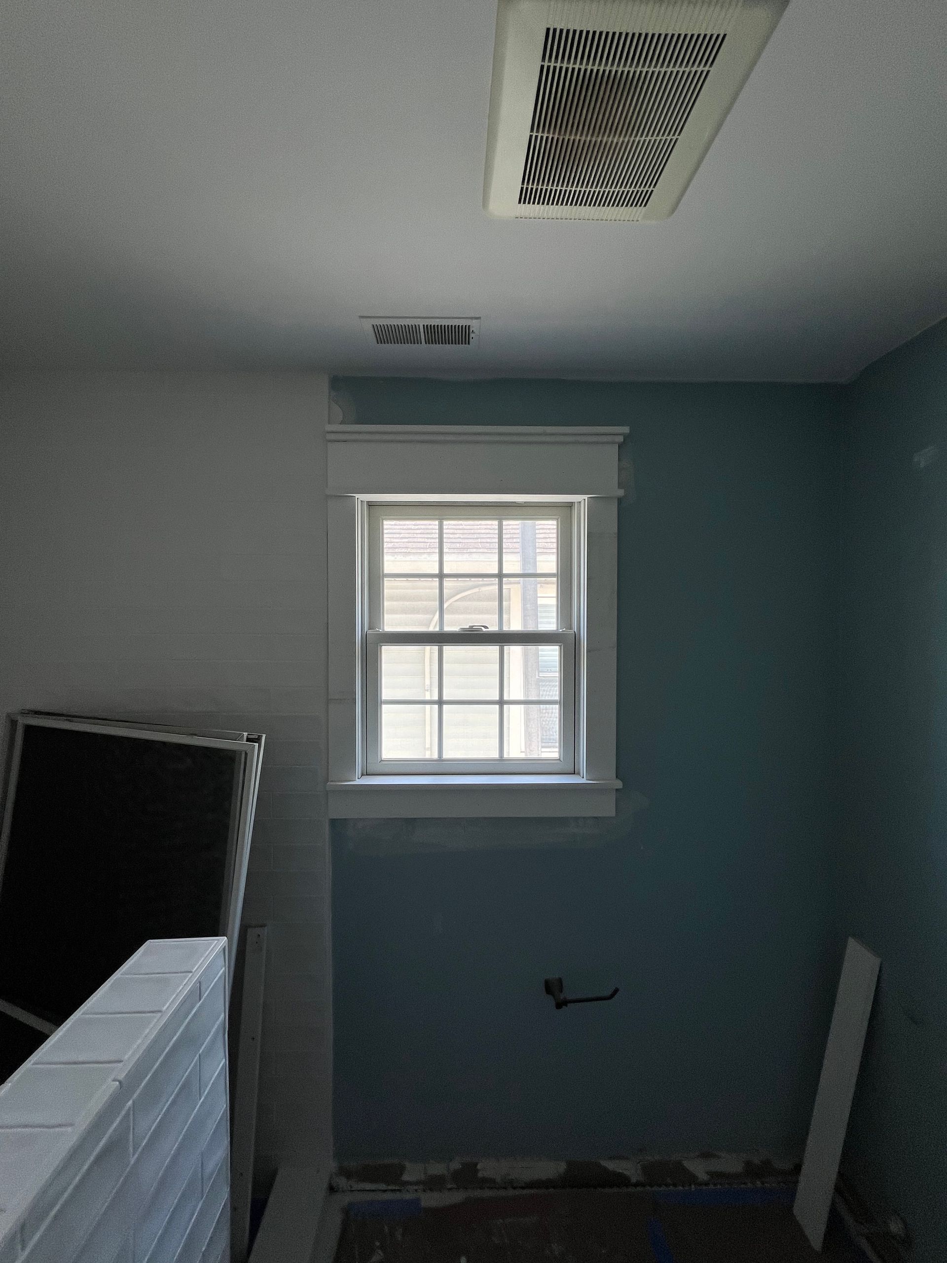 An empty room with a window and a ceiling fan