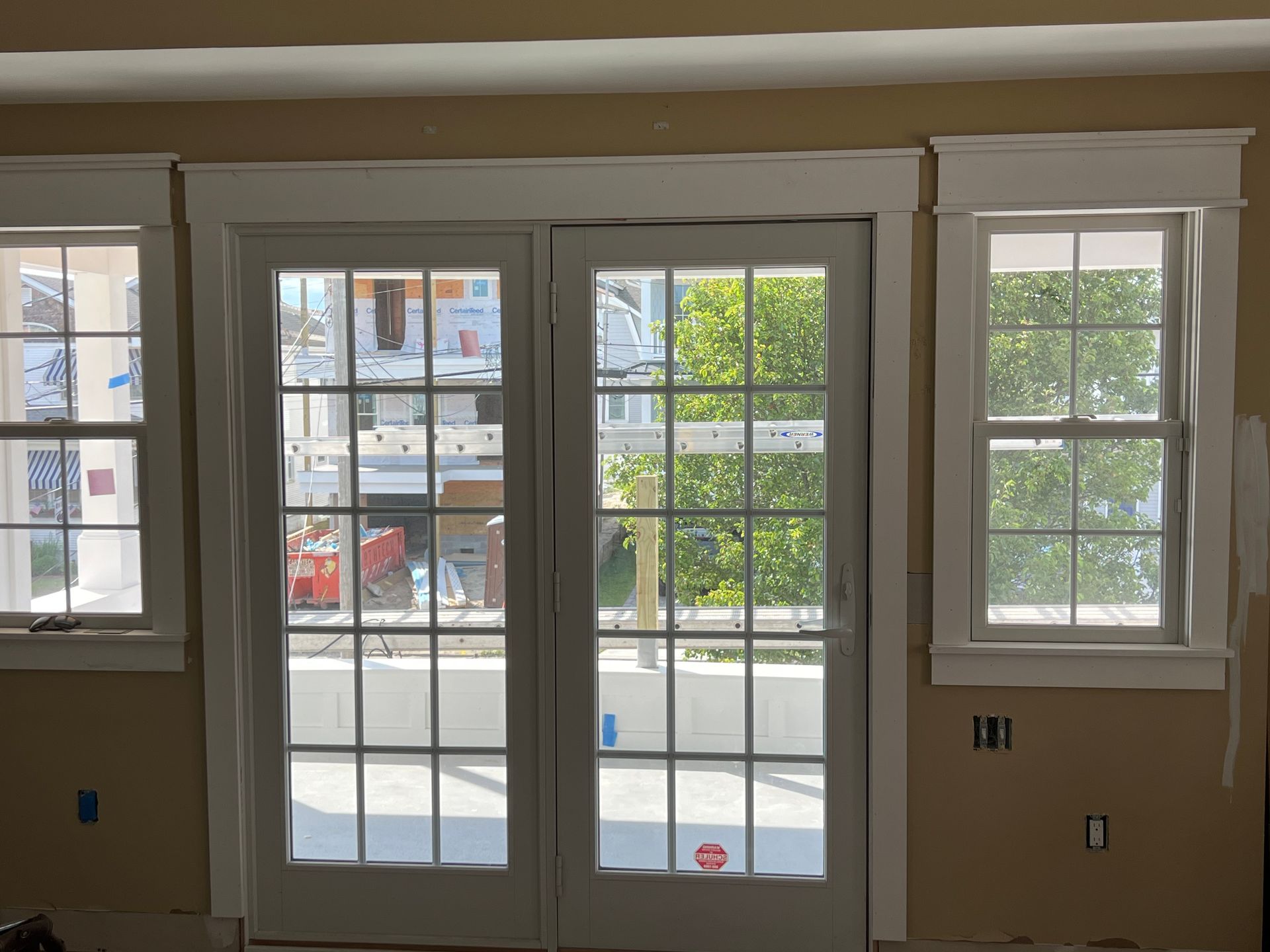 A room with a sliding glass door and two windows
