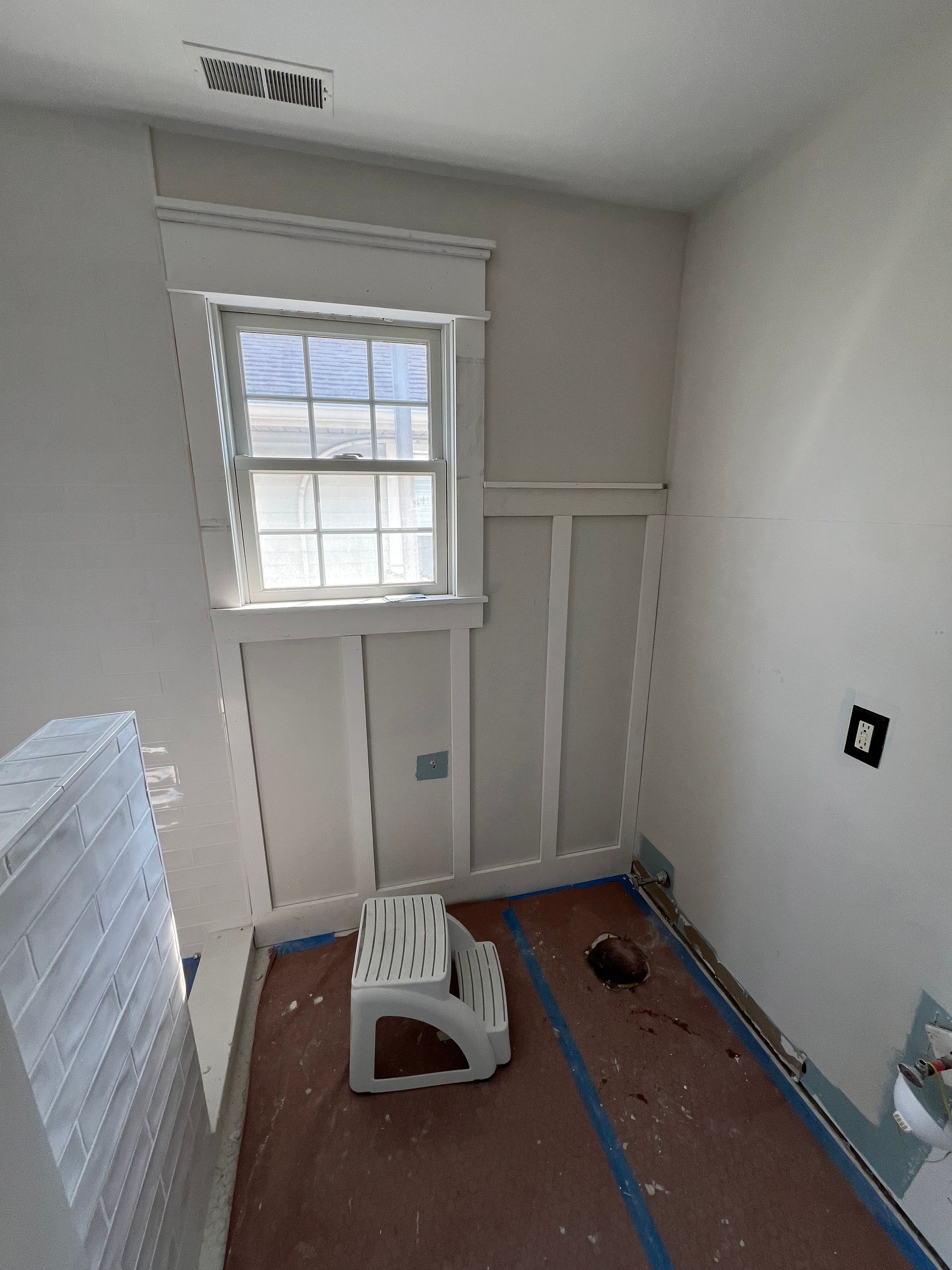 A room with a window and a stool in it